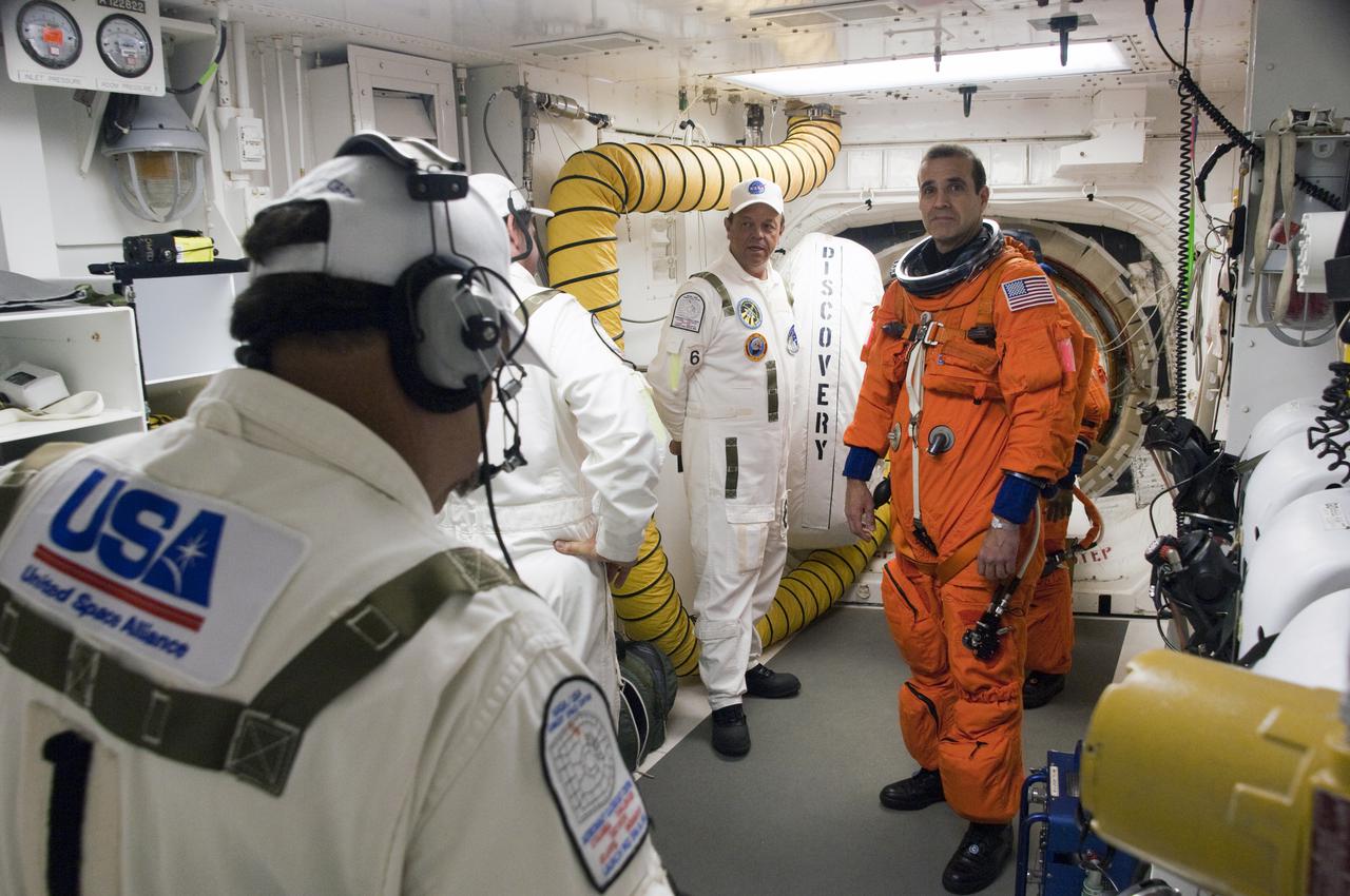 CAPE CANAVERAL, Fla. - In the White Room at Launch Pad 39A at NASA's Kennedy Space Center in Florida, United Space Alliance space suit technicians ensure that the launch-and-entry suit of STS-131 Mission Specialist Rick Mastracchio fits properly before he enters space shuttle Discovery through the crew hatch in the background.  Liftoff of the STS-131 mission is set for 6:21 a.m. EDT on April 5. On STS-131, the seven-member crew will deliver the multi-purpose logistics module Leonardo, filled with supplies, a new crew sleeping quarters and science racks that will be transferred to the International Space Station's laboratories.  The crew also will switch out a gyroscope on the station’s truss, install a spare ammonia storage tank and retrieve a Japanese experiment from the station’s exterior.  STS-131 is the 33rd shuttle mission to the station and the 131st shuttle mission overall. For information on the STS-131 mission and crew, visit http:__www.nasa.gov_mission_pages_shuttle_shuttlemissions_sts131_index.html.  Photo credit: NASA_Sandra Joseph and Kevin O'Connell