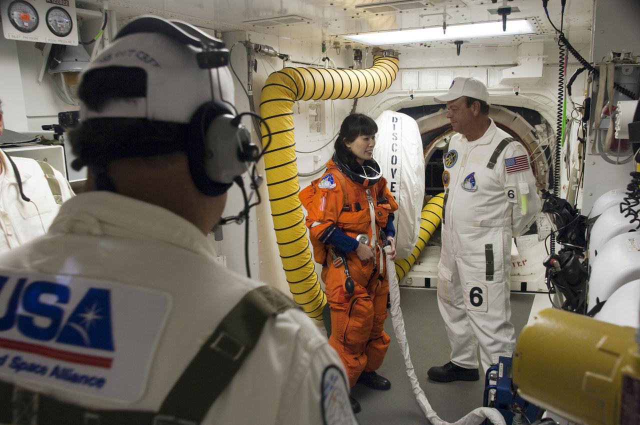 CAPE CANAVERAL, Fla. - In the White Room at Launch Pad 39A at NASA's Kennedy Space Center in Florida, United Space Alliance space suit technicians ensure that the launch-and-entry suit of STS-131 Mission Specialist Naoko Yamazaki, of the Japan Aerospace Exploration Agency, fits properly before she enters space shuttle Discovery through the crew hatch in the background.  Liftoff of the STS-131 mission is set for 6:21 a.m. EDT on April 5. On STS-131, the seven-member crew will deliver the multi-purpose logistics module Leonardo, filled with supplies, a new crew sleeping quarters and science racks that will be transferred to the International Space Station's laboratories.  The crew also will switch out a gyroscope on the station’s truss, install a spare ammonia storage tank and retrieve a Japanese experiment from the station’s exterior.  STS-131 is the 33rd shuttle mission to the station and the 131st shuttle mission overall. For information on the STS-131 mission and crew, visit http:__www.nasa.gov_mission_pages_shuttle_shuttlemissions_sts131_index.html.  Photo credit: NASA_Sandra Joseph and Kevin O'Connell