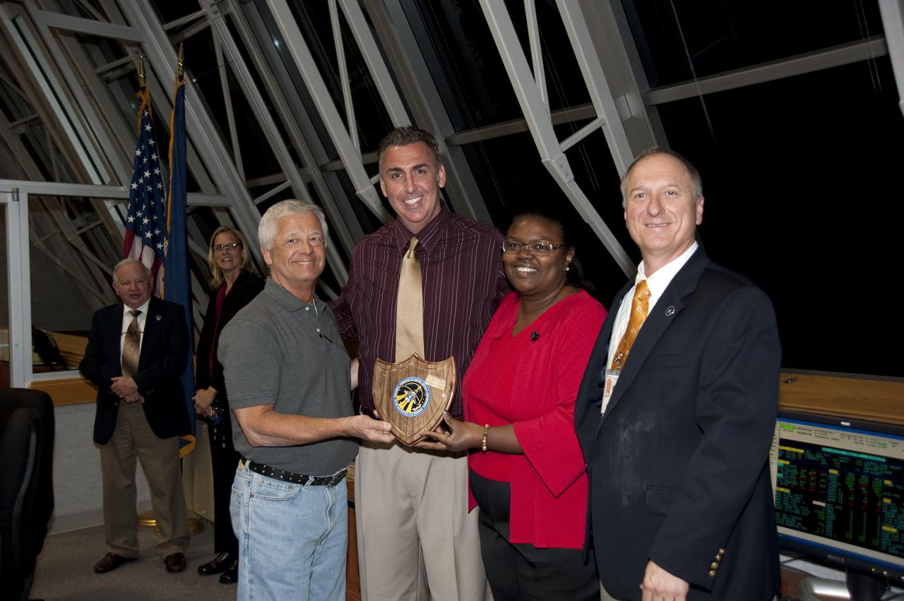 CAPE CANAVERAL, Fla.  - STS-131 Launch Director Pete Nickolenko (right) proudly stands next to Nita Collins with USA Firing Room Quality Control, Dallas McCarter, NASA Safety and  Jim Marczak with USA Logistics, after presenting them with the Launch Director’s Flow award after the liftoff of shuttle Discovery on the STS-131 mission.  Shuttle Discovery lifted off at 6:21 a.m. EDT on April 5, 2010. The seven-member STS-131 crew will deliver the multi-purpose logistics module Leonardo, filled with supplies, a new crew sleeping quarters and science racks that will be transferred to the International Space Station's laboratories. The crew also will switch out a gyroscope on the station’s truss, install a spare ammonia storage tank and retrieve a Japanese experiment from the station’s exterior. STS-131 is the 33rd shuttle mission to the station and the 131st shuttle mission overall. For information on the STS-131 mission and crew, visit http:__www.nasa.gov_mission_pages_shuttle_shuttlemissions_sts131_index.html. Photo credit: NASA_Kim Shiflett
