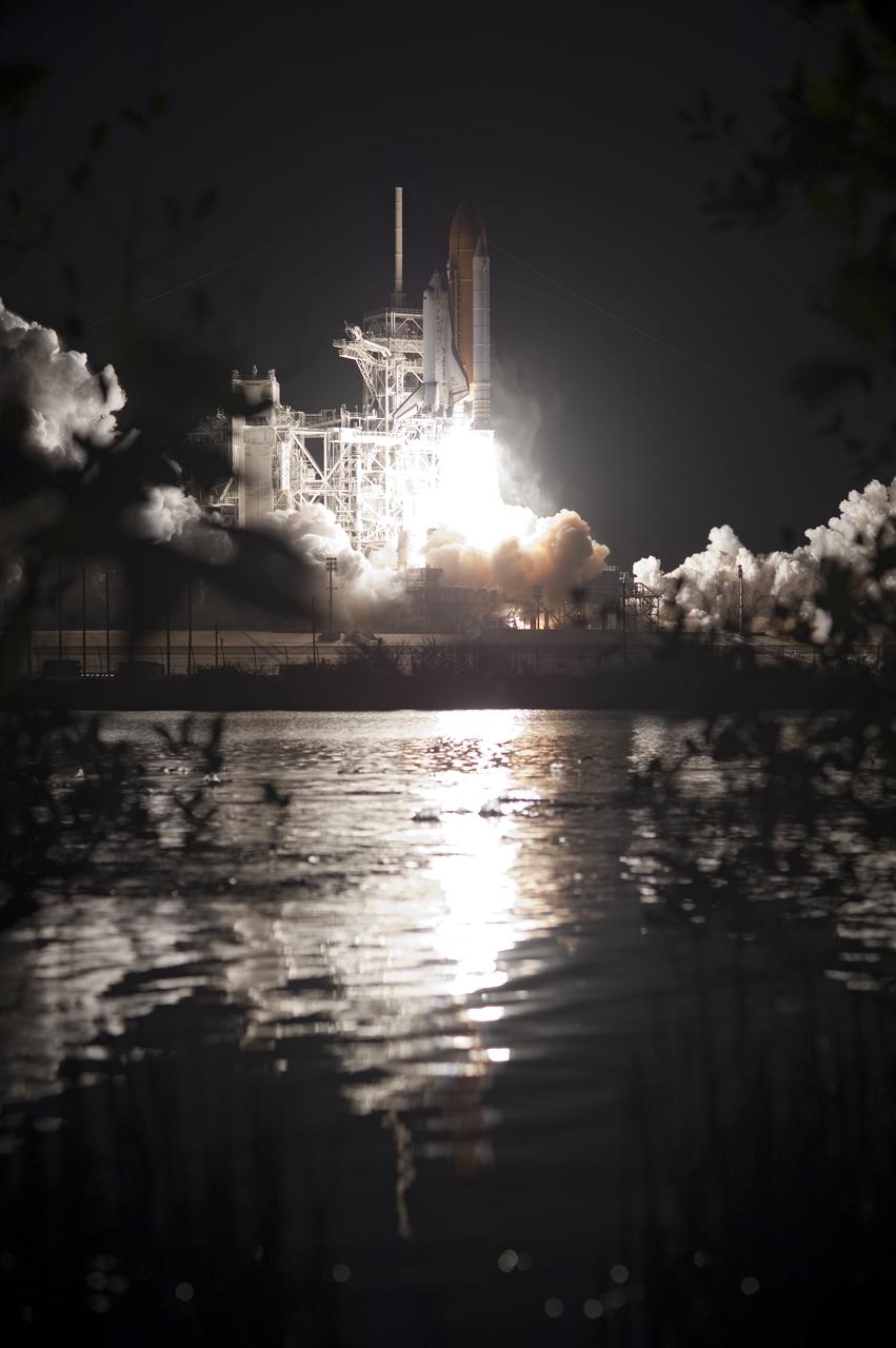CAPE CANAVERAL, Fla.  - Space shuttle Discovery blasts off in a blaze of fire and clouds seen reflected in waters surrounding Launch Pad 39A at NASA's Kennedy Space Center in Florida on the STS-131 mission.  Shuttle Discovery lifted off at 6:21 a.m. EDT on April 5, 2010. The seven-member STS-131 crew will deliver the multi-purpose logistics module Leonardo, filled with supplies, a new crew sleeping quarters and science racks that will be transferred to the International Space Station's laboratories. The crew also will switch out a gyroscope on the station’s truss, install a spare ammonia storage tank and retrieve a Japanese experiment from the station’s exterior. STS-131 is the 33rd shuttle mission to the station and the 131st shuttle mission overall. For information on the STS-131 mission and crew, visit http:__www.nasa.gov_mission_pages_shuttle_shuttlemissions_sts131_index.html.  Photo credit: NASA_Tony Gray and Tom Farrar