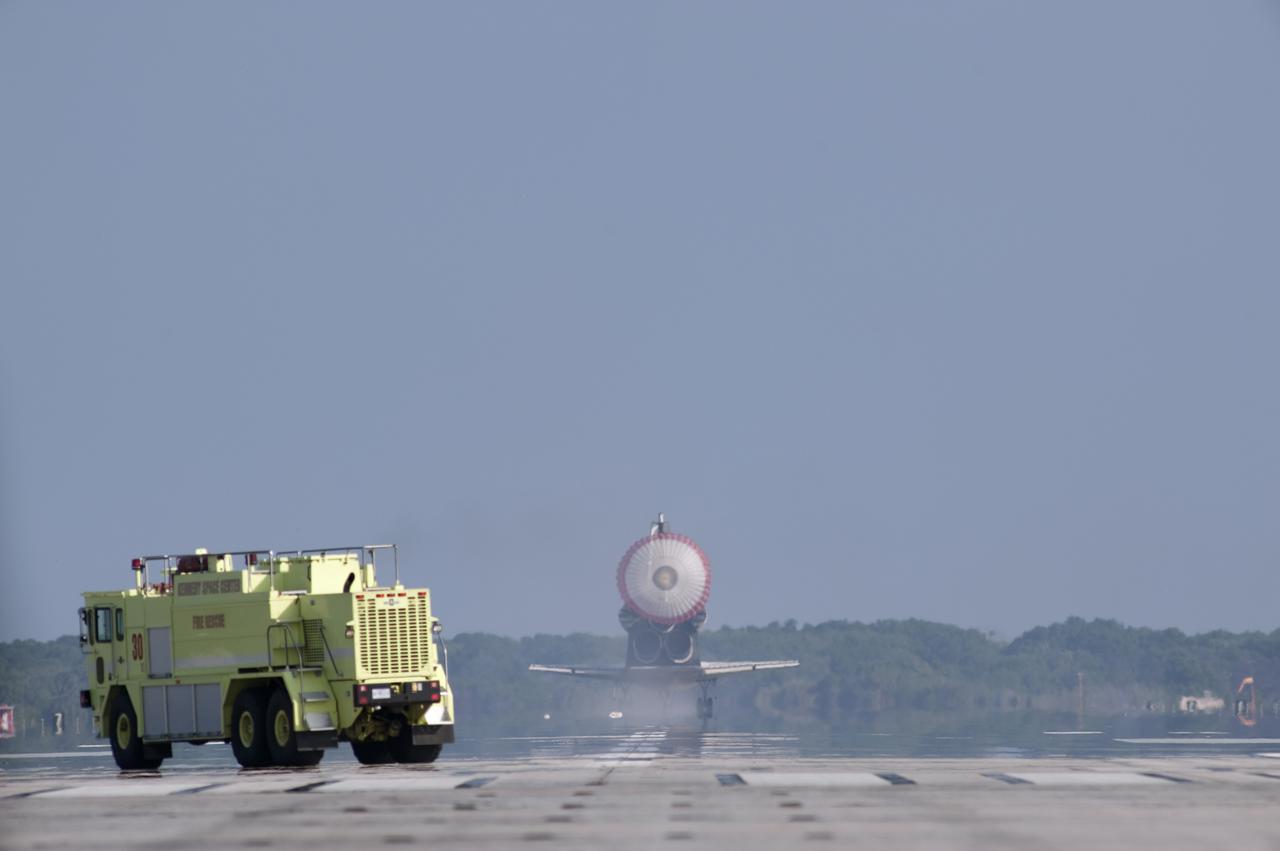 CAPE CANAVERAL, Fla. - With drag chute unfurled, space shuttle Discovery rolls past a fire rescue vehicle on Runway 33 as it lands at the Shuttle Landing Facility at NASA's Kennedy Space Center in Florida after 15 days in space, completing the more than 6.2-million-mile STS-131 mission on orbit 238.  Main gear touchdown was at 9:08:35 a.m. EDT followed by nose gear touchdown at 9:08:47 a.m. and wheelstop at 9:09:33 a.m.  Aboard are Commander Alan Poindexter; Pilot James P. Dutton Jr.; and Mission Specialists Rick Mastracchio, Clayton Anderson, Dorothy Metcalf-Lindenburger, Stephanie Wilson and Naoko Yamazaki of the Japan Aerospace Exploration Agency.  The seven-member STS-131 crew carried the multi-purpose logistics module Leonardo, filled with supplies, a new crew sleeping quarters and science racks that were transferred to the International Space Station's laboratories.  The crew also switched out a gyroscope on the station’s truss, installed a spare ammonia storage tank and retrieved a Japanese experiment from the station’s exterior.  STS-131 is the 33rd shuttle mission to the station and the 131st shuttle mission overall. For information on the STS-131 mission and crew, visit http:__www.nasa.gov_mission_pages_shuttle_shuttlemissions_sts131_index.html.  Photo credit: NASA_Tony Gray and Tom Farrar