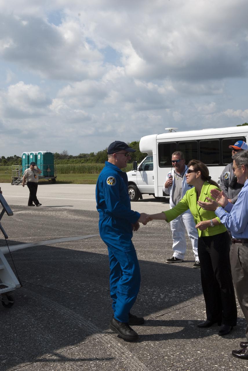 CAPE CANAVERAL, Fla. - At the Shuttle Landing Facility at NASA's Kennedy Space Center in Florida, NASA Deputy Administrator Lori Garver welcomes STS-131 Commander Alan Poindexter back from space following the landing of space shuttle Discovery on Runway 33.  Kennedy Director Bob Cabana applauds Cabana for his successful mission, at right.  Discovery landed at Kennedy after 15 days in space, completing the more than 6.2-million-mile STS-131 mission on orbit 238.  Main gear touchdown was at 9:08:35 a.m. EDT followed by nose gear touchdown at 9:08:47 a.m. and wheelstop at 9:09:33 a.m.  The seven-member STS-131 crew carried the multi-purpose logistics module Leonardo, filled with supplies, a new crew sleeping quarters and science racks that were transferred to the International Space Station's laboratories.  The crew also switched out a gyroscope on the station’s truss, installed a spare ammonia storage tank and retrieved a Japanese experiment from the station’s exterior.  STS-131 is the 33rd shuttle mission to the station and the 131st shuttle mission overall. For information on the STS-131 mission and crew, visit http:__www.nasa.gov_mission_pages_shuttle_shuttlemissions_sts131_index.html.  Photo credit: NASA_Jim Grossmann