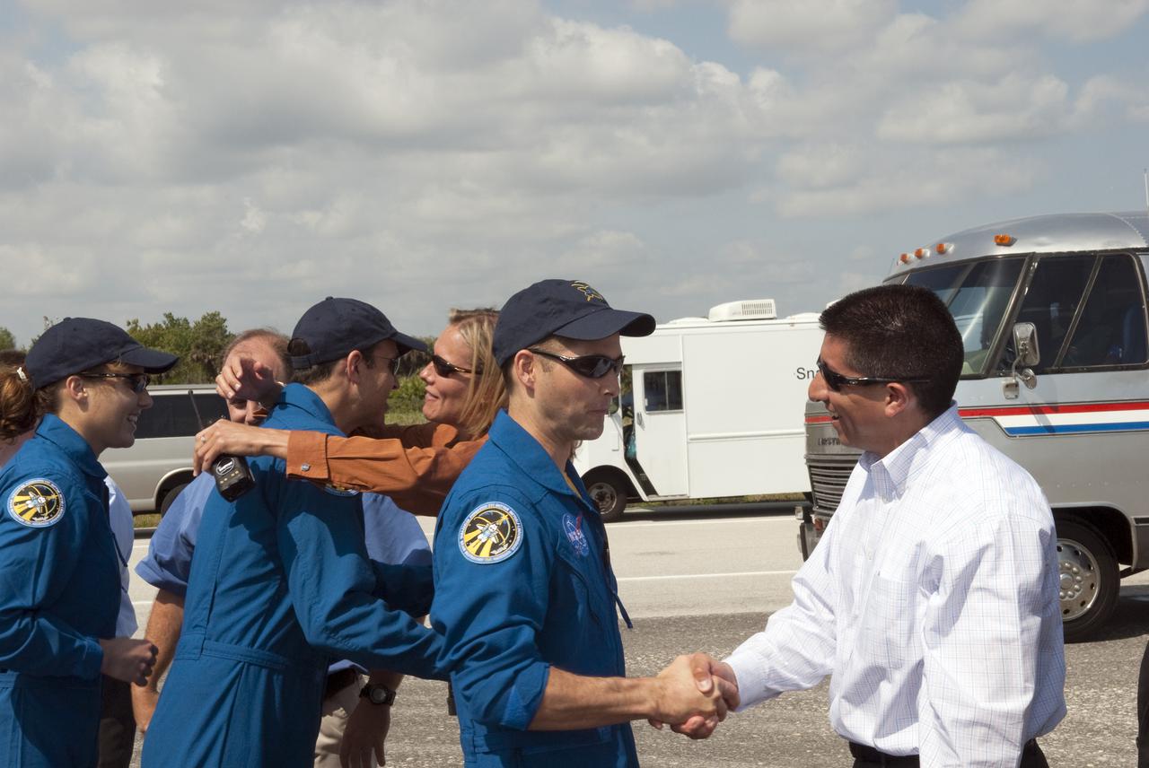 CAPE CANAVERAL, Fla. - At the Shuttle Landing Facility at NASA's Kennedy Space Center in Florida, STS-131 Pilot James P. Dutton Jr. is congratulated on a successful mission by NASA Flight Director Richard Jones from the Johnson Space Center, at right, as space shuttle Discovery's flow director, Stephanie Stilson, welcomes Mission Specialist Rick Mastracchio back from space.  Mission Specialist Dorothy Metcalf-Lindenburger, at left, awaits her turn to talk to Stilson.  Discovery landed at Kennedy after 15 days in space, completing the more than 6.2-million-mile STS-131 mission on orbit 238.  Main gear touchdown was at 9:08:35 a.m. EDT followed by nose gear touchdown at 9:08:47 a.m. and wheelstop at 9:09:33 a.m.  The seven-member STS-131 crew carried the multi-purpose logistics module Leonardo, filled with supplies, a new crew sleeping quarters and science racks that were transferred to the International Space Station's laboratories.  The crew also switched out a gyroscope on the station’s truss, installed a spare ammonia storage tank and retrieved a Japanese experiment from the station’s exterior.  STS-131 is the 33rd shuttle mission to the station and the 131st shuttle mission overall. For information on the STS-131 mission and crew, visit http:__www.nasa.gov_mission_pages_shuttle_shuttlemissions_sts131_index.html.  Photo credit: NASA_Jim Grossmann