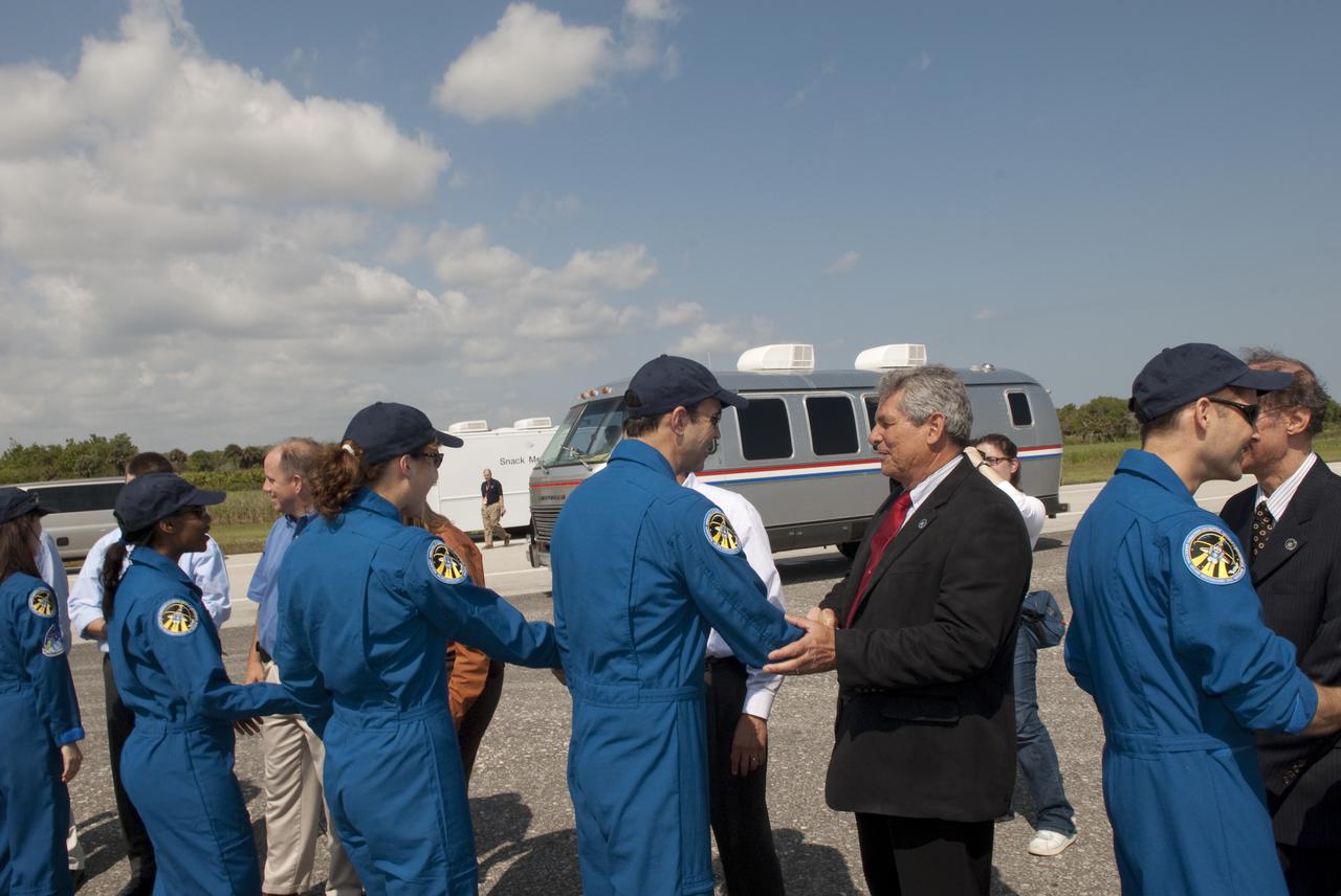 CAPE CANAVERAL, Fla. - At the Shuttle Landing Facility at NASA's Kennedy Space Center in Florida, Larry Ostarly (red tie), director of Ground Systems Support, United Space Alliance, welcomes STS-131 Mission Specialist Rick Mastracchio back from space following the landing of space shuttle Discovery on Runway 33.  Also moving down the receiving line, from left, are STS-131 Mission Specialists Naoko Yamazaki of the Japan Aerospace Exploration Agency, Stephanie Wilson, and Dorothy Metcalf-Lindenburger; and Pilot James P. Dutton Jr., at right.  Discovery landed at Kennedy after 15 days in space, completing the more than 6.2-million-mile STS-131 mission on orbit 238.  Main gear touchdown was at 9:08:35 a.m. EDT followed by nose gear touchdown at 9:08:47 a.m. and wheelstop at 9:09:33 a.m.  The seven-member STS-131 crew carried the multi-purpose logistics module Leonardo, filled with supplies, a new crew sleeping quarters and science racks that were transferred to the International Space Station's laboratories.  The crew also switched out a gyroscope on the station’s truss, installed a spare ammonia storage tank and retrieved a Japanese experiment from the station’s exterior.  STS-131 is the 33rd shuttle mission to the station and the 131st shuttle mission overall. For information on the STS-131 mission and crew, visit http:__www.nasa.gov_mission_pages_shuttle_shuttlemissions_sts131_index.html.  Photo credit: NASA_Jim Grossmann