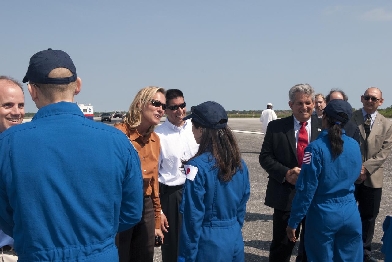 CAPE CANAVERAL, Fla. - At the Shuttle Landing Facility at NASA's Kennedy Space Center in Florida, at center, space shuttle Discovery Flow Director Stephanie Stilson talks to STS-131 Mission Specialist Naoko Yamazaki of the Japan Aerospace Exploration Agency about her successful mission as NASA Flight Director Richard Jones from the Johnson Space Center looks on.  At right, Larry Ostarly (red tie), director of Ground Systems Support, United Space Alliance, welcomes STS-131 Mission Specialist Stephanie Wilson back from space with James Cawby, director of Manufacturing and Processing, Launch and Recovery Systems, United Space Alliance, at right, awaiting his turn.  Making his way down the receifing line, at left, is Mission Specialist Clayton Anderson.  Discovery landed at Kennedy after 15 days in space, completing the more than 6.2-million-mile STS-131 mission on orbit 238.  Main gear touchdown was at 9:08:35 a.m. EDT followed by nose gear touchdown at 9:08:47 a.m. and wheelstop at 9:09:33 a.m.  The seven-member STS-131 crew carried the multi-purpose logistics module Leonardo, filled with supplies, a new crew sleeping quarters and science racks that were transferred to the International Space Station's laboratories.  The crew also switched out a gyroscope on the station’s truss, installed a spare ammonia storage tank and retrieved a Japanese experiment from the station’s exterior.  STS-131 is the 33rd shuttle mission to the station and the 131st shuttle mission overall. For information on the STS-131 mission and crew, visit http:__www.nasa.gov_mission_pages_shuttle_shuttlemissions_sts131_index.html.  Photo credit: NASA_Jim Grossmann