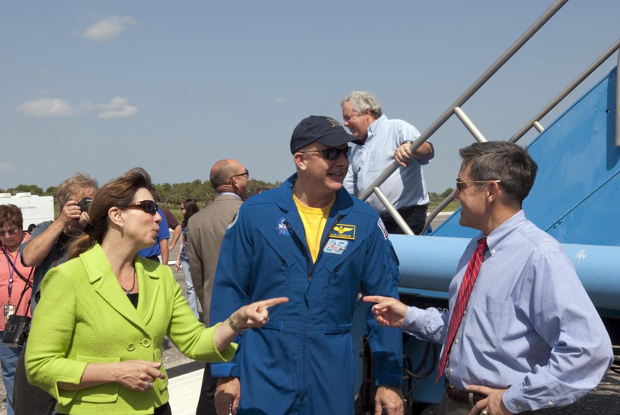 CAPE CANAVERAL, Fla. - At the Shuttle Landing Facility at NASA's Kennedy Space Center in Florida, NASA Deputy Administrator Lori Garver, left, and Kennedy Director Bob Cabana, right, welcome STS-131 Commander Alan Poindexter back to Florida following the landing of space shuttle Discovery on Runway 33.  Discovery landed at Kennedy after 15 days in space, completing the more than 6.2-million-mile STS-131 mission on orbit 238.  Main gear touchdown was at 9:08:35 a.m. EDT followed by nose gear touchdown at 9:08:47 a.m. and wheelstop at 9:09:33 a.m.  The seven-member STS-131 crew carried the multi-purpose logistics module Leonardo, filled with supplies, a new crew sleeping quarters and science racks that were transferred to the International Space Station's laboratories.  The crew also switched out a gyroscope on the station’s truss, installed a spare ammonia storage tank and retrieved a Japanese experiment from the station’s exterior.  STS-131 is the 33rd shuttle mission to the station and the 131st shuttle mission overall. For information on the STS-131 mission and crew, visit http:__www.nasa.gov_mission_pages_shuttle_shuttlemissions_sts131_index.html.  Photo credit: NASA_Jim Grossmann