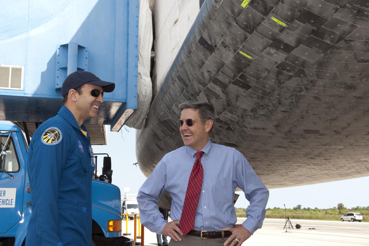 CAPE CANAVERAL, Fla. - At the Shuttle Landing Facility at NASA's Kennedy Space Center in Florida, STS-131 Mission Specialist Rich Mastracchio, left, and Kennedy Director Bob Cabana are all smiles as they get a close look at Discovery following the shuttle's landing on Runway 33.  Discovery landed at Kennedy after 15 days in space, completing the more than 6.2-million-mile STS-131 mission on orbit 238.  Main gear touchdown was at 9:08:35 a.m. EDT followed by nose gear touchdown at 9:08:47 a.m. and wheelstop at 9:09:33 a.m.  The seven-member STS-131 crew carried the multi-purpose logistics module Leonardo, filled with supplies, a new crew sleeping quarters and science racks that were transferred to the International Space Station's laboratories.  The crew also switched out a gyroscope on the station’s truss, installed a spare ammonia storage tank and retrieved a Japanese experiment from the station’s exterior.  STS-131 is the 33rd shuttle mission to the station and the 131st shuttle mission overall. For information on the STS-131 mission and crew, visit http:__www.nasa.gov_mission_pages_shuttle_shuttlemissions_sts131_index.html.  Photo credit: NASA_Jim Grossmann