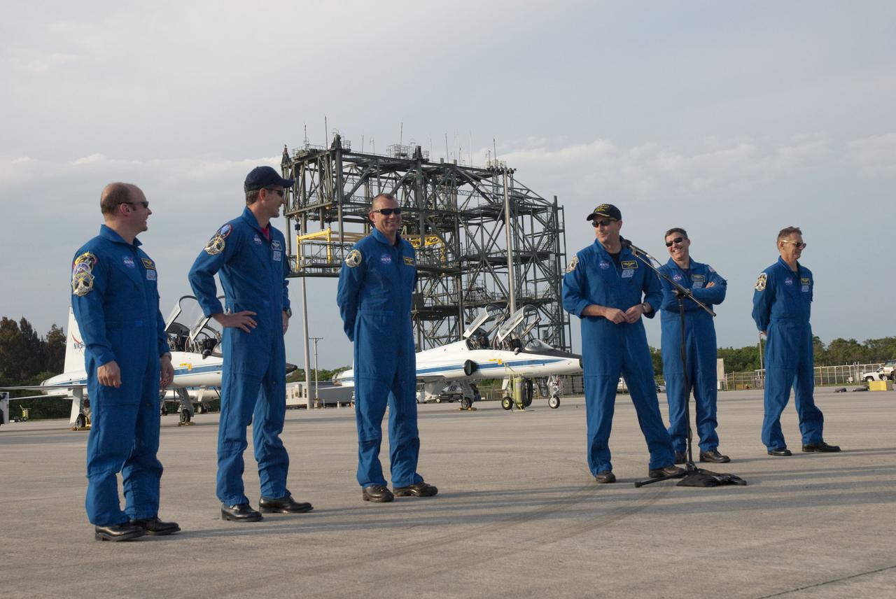 CAPE CANAVERAL, Fla. - At NASA's Kennedy Space Center in Florida, STS-132 Commander Ken Ham announces to media representatives gathered for his crew’s arrival for a practice launch dress rehearsal called the Terminal Countdown Demonstration Test, or TCDT, that Pilot Tony Antonelli has recently been promoted to the rank of captain in the U.S. Navy. From left are Mission Specialists Garrett Reisman and Michael Good; Antonelli; Ham, at the microphone; and Mission Specialists Steve Bowen and Piers Sellers. In the background is a mate-demate device, used to lift the shuttle on or off the back of a Shuttle Carrier Aircraft. The STS-132 crew arrived at Kennedy’s Shuttle Landing Facility at 6:11 p.m. EDT aboard four T-38 jets. TCDT provides each shuttle crew and launch team with an opportunity to participate in various simulated countdown activities, including equipment familiarization and emergency training. On the STS-132 mission, the six-member crew will deliver an Integrated Cargo Carrier, or ICC, and the Russian-built Mini-Research Module-1, or MRM-1, to the International Space Station aboard space shuttle Atlantis. The ICC is an unpressurized flat bed pallet and keel yoke assembly used to support the transfer of exterior cargo from the shuttle to the space station. The MRM-1, known as Rassvet, is the second in a series of new pressurized components for Russia and will be permanently attached to the Earth-facing port of the Zarya control module. Rassvet, which translates to 'dawn,' will be used for cargo storage and will provide an additional docking port to the station. STS-132 is the 34th mission to the station and the 132nd shuttle mission overall. Atlantis is targeted to launch on May 14 at 2:19 p.m. For information on the STS-132 mission, visit http:__www.nasa.gov_mission_pages_shuttle_shuttlemissions_sts132_index.html. Photo credit: NASA_Cory Huston