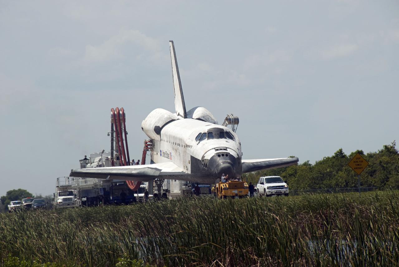 CAPE CANAVERAL, Fla. - At NASA's Kennedy Space Center in Florida, space shuttle Discovery makes its slow trek from the Shuttle Landing Facility to Orbiter Processing Facility-3 following its successful landing on Runway 33.  Discovery landed at Kennedy after 15 days in space, completing the more than 6.2-million-mile STS-131 mission on orbit 238.  Main gear touchdown was at 9:08:35 a.m. EDT followed by nose gear touchdown at 9:08:47 a.m. and wheelstop at 9:09:33 a.m.  Aboard were Commander Alan Poindexter; Pilot James P. Dutton Jr.; and Mission Specialists Rick Mastracchio, Clayton Anderson, Dorothy Metcalf-Lindenburger, Stephanie Wilson and Naoko Yamazaki of the Japan Aerospace Exploration Agency.  The seven-member STS-131 crew carried the multi-purpose logistics module Leonardo, filled with supplies, a new crew sleeping quarters and science racks that were transferred to the International Space Station's laboratories.  The crew also switched out a gyroscope on the station’s truss, installed a spare ammonia storage tank and retrieved a Japanese experiment from the station’s exterior.  STS-131 is the 33rd shuttle mission to the station and the 131st shuttle mission overall. For information on the STS-131 mission and crew, visit http:__www.nasa.gov_mission_pages_shuttle_shuttlemissions_sts131_index.html.  Photo credit: NASA_Jim Grossmann