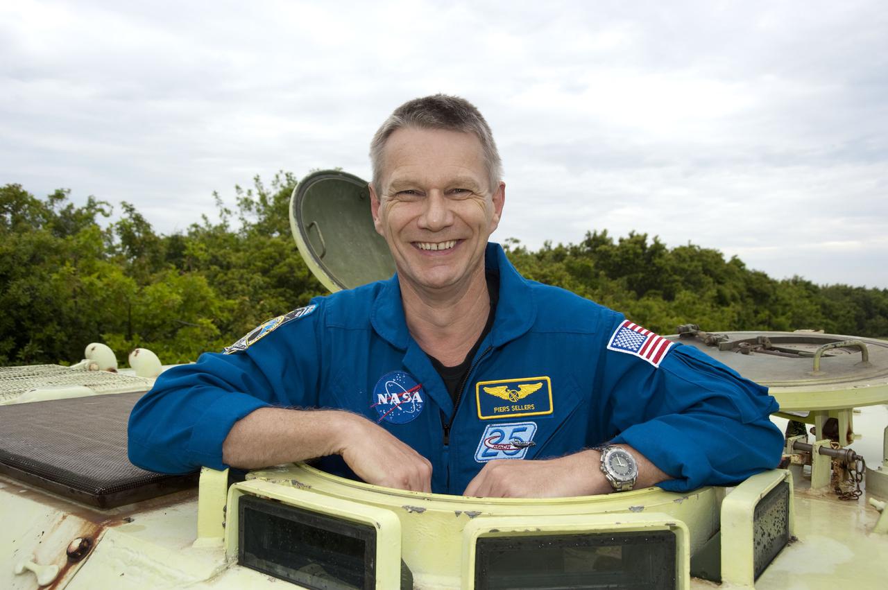 CAPE CANAVERAL, Fla. - At NASA's Kennedy Space Center in Florida, STS-132 Mission Specialist Piers Sellers takes time out from his M-113 armored personnel carrier training to pose for the camera.  An M-113 is kept at the foot of the launch pad in case an emergency egress from the vicinity of the pad is needed.  The STS-132 crew is participating in their Terminal Countdown Demonstration Test, or TCDT, a dress rehearsal for launch.  TCDT provides each shuttle crew and launch team the opportunity to participate in various simulated countdown activities, including equipment familiarization and emergency training.  On the STS-132 mission, the six-member crew will deliver an Integrated Cargo Carrier, or ICC, and the Russian-built Mini-Research Module-1, or MRM-1, to the International Space Station aboard space shuttle Atlantis.  The ICC is an unpressurized flat bed pallet and keel yoke assembly used to support the transfer of exterior cargo from the shuttle to the space station.  The MRM-1, known as Rassvet, is the second in a series of new pressurized components for Russia and will be permanently attached to the Earth-facing port of the Zarya control module. Rassvet, which translates to 'dawn,' will be used for cargo storage and will provide an additional docking port to the station.  STS-132 is the 34th mission to the station and the 132nd shuttle mission overall.   Atlantis is targeted to launch on May 14 at 2:19 p.m.  For information on the STS-132 mission, visit http:__www.nasa.gov_mission_pages_shuttle_shuttlemissions_sts132_index.html. Photo credit: NASA_Kim Shiflett