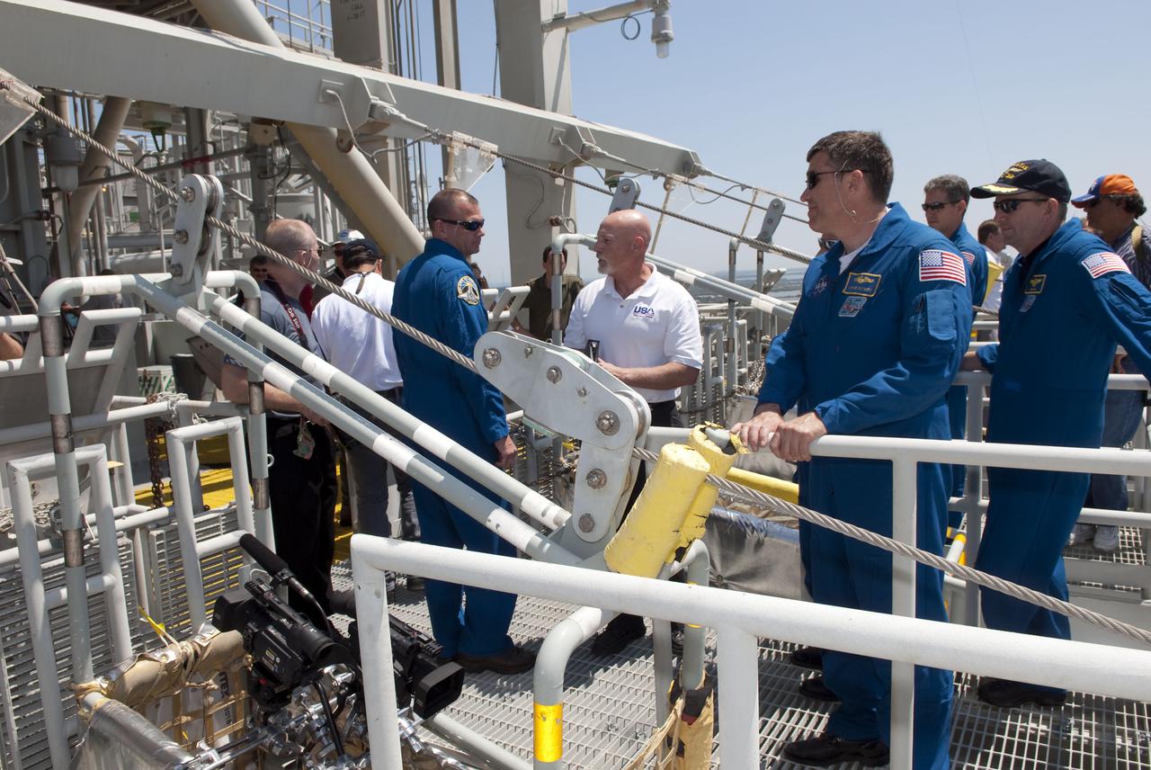 CAPE CANAVERAL, Fla. - On Launch Pad 39A at NASA's Kennedy Space Center, the members of space shuttle Atlantis' STS-132 crew receive instruction on the operation of the pad's slidewire basket system during emergency exit training.  In the blue flight suits, from left, are Pilot Tony Antonelli, Mission Specialists Steve Bowen and Michael Good, and Commander Ken Ham.  The pad's escape system includes seven baskets suspended from seven slidewires that extend from the fixed service structure to a landing zone 1,200 feet west of the pad.  The crew is participating in training in preparation for their Terminal Countdown Demonstration Test, or TCDT, a dress rehearsal for launch.  TCDT provides each shuttle crew and launch team the opportunity to participate in various simulated countdown activities, including equipment familiarization and emergency procedures.  On the STS-132 mission, the six-member crew will deliver an Integrated Cargo Carrier, or ICC, and the Russian-built Mini-Research Module-1, or MRM-1, to the International Space Station aboard space shuttle Atlantis.  The ICC is an unpressurized flat bed pallet and keel yoke assembly used to support the transfer of exterior cargo from the shuttle to the space station.  The MRM-1, known as Rassvet, is the second in a series of new pressurized components for Russia and will be permanently attached to the Earth-facing port of the Zarya control module. Rassvet, which translates to 'dawn,' will be used for cargo storage and will provide an additional docking port to the station.  STS-132 is the 34th mission to the station and the 132nd shuttle mission overall.   Atlantis is targeted to launch on May 14 at 2:19 p.m.  For information on the STS-132 mission, visit http:__www.nasa.gov_mission_pages_shuttle_shuttlemissions_sts132_index.html. Photo credit: NASA_Jim Grossmann