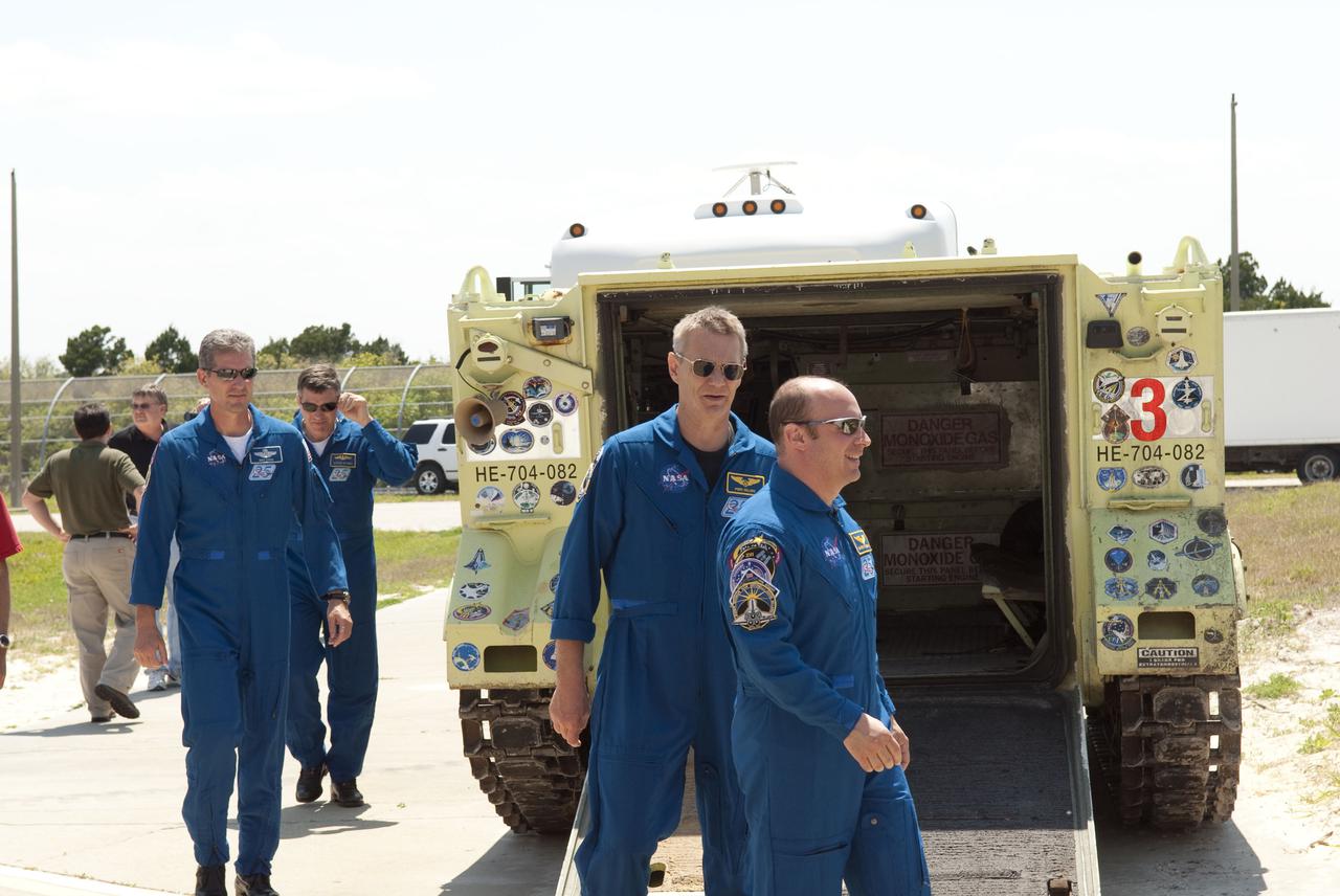 CAPE CANAVERAL, Fla. - At Launch Pad 39A at NASA's Kennedy Space Center, the members of space shuttle Atlantis' STS-132 crew receive instruction on the location and operation of an M-113 armored personnel carrier during emergency exit training.  The M-113 is stationed at the base of the pad.  In the blue flight suits, from left, are Mission Specialists Michael Good, Steve Bowen, Piers Sellers and Garrett Reisman.  The crew is participating in training in preparation for their Terminal Countdown Demonstration Test, or TCDT, a dress rehearsal for launch.  TCDT provides each shuttle crew and launch team the opportunity to participate in various simulated countdown activities, including equipment familiarization and emergency procedures.  On the STS-132 mission, the six-member crew will deliver an Integrated Cargo Carrier, or ICC, and the Russian-built Mini-Research Module-1, or MRM-1, to the International Space Station aboard space shuttle Atlantis.  The ICC is an unpressurized flat bed pallet and keel yoke assembly used to support the transfer of exterior cargo from the shuttle to the space station.  The MRM-1, known as Rassvet, is the second in a series of new pressurized components for Russia and will be permanently attached to the Earth-facing port of the Zarya control module. Rassvet, which translates to 'dawn,' will be used for cargo storage and will provide an additional docking port to the station.  STS-132 is the 34th mission to the station and the 132nd shuttle mission overall.   Atlantis is targeted to launch on May 14 at 2:19 p.m.  For information on the STS-132 mission, visit http:__www.nasa.gov_mission_pages_shuttle_shuttlemissions_sts132_index.html. Photo credit: NASA_Jim Grossmann