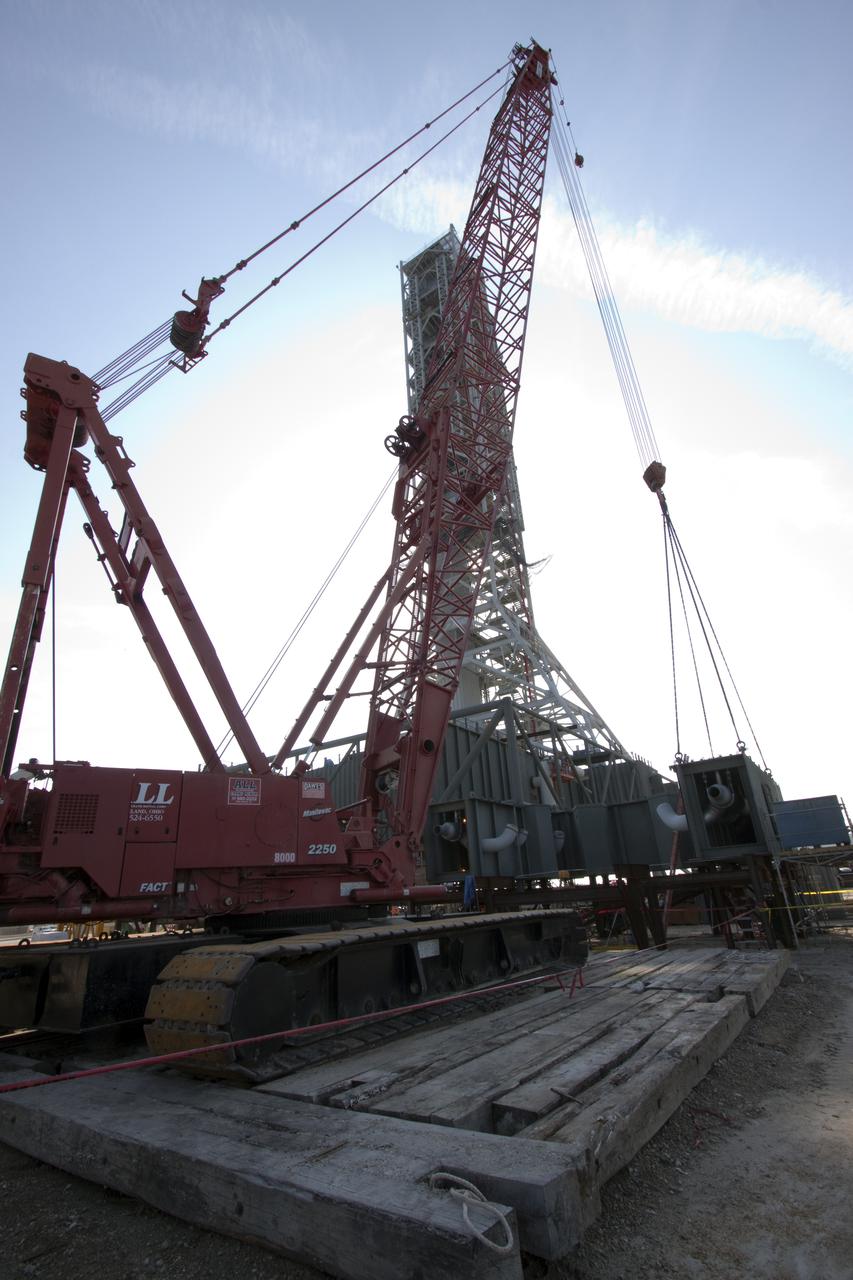 CAPE CANAVERAL, Fla. – At NASA's Kennedy Space Center in Florida, a crane is enlisted to support the arrival of the third segment of the launch mount for a new mobile launcher, or ML, being constructed to support NASA's future human spaceflight program.  The construction is taking place in the mobile launcher park site north of Kennedy's Vehicle Assembly Building.  The new launcher is 355 feet tall and has multiple platforms for personnel access. The base of the launcher is lighter than space shuttle mobile launcher platforms so the crawler-transporter can pick up the heavier load of the tower and a taller rocket. For information on NASA's future plans, visit http:__www.nasa.gov. Photo credit: NASA_Jack Pfaller
