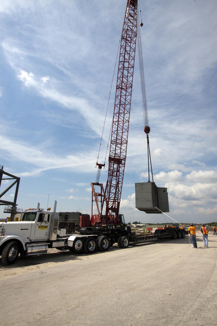 CAPE CANAVERAL, Fla. – At NASA's Kennedy Space Center in Florida, a crane lifts the third segment of the launch mount for a new mobile launcher, or ML, being constructed to support NASA's future human spaceflight program from the tractor-trailer on which it arrived.  The construction is taking place in the mobile launcher park site north of Kennedy's Vehicle Assembly Building.  The new launcher is 355 feet tall and has multiple platforms for personnel access. The base of the launcher is lighter than space shuttle mobile launcher platforms so the crawler-transporter can pick up the heavier load of the tower and a taller rocket. For information on NASA's future plans, visit http:__www.nasa.gov. Photo credit: NASA_Jack Pfaller