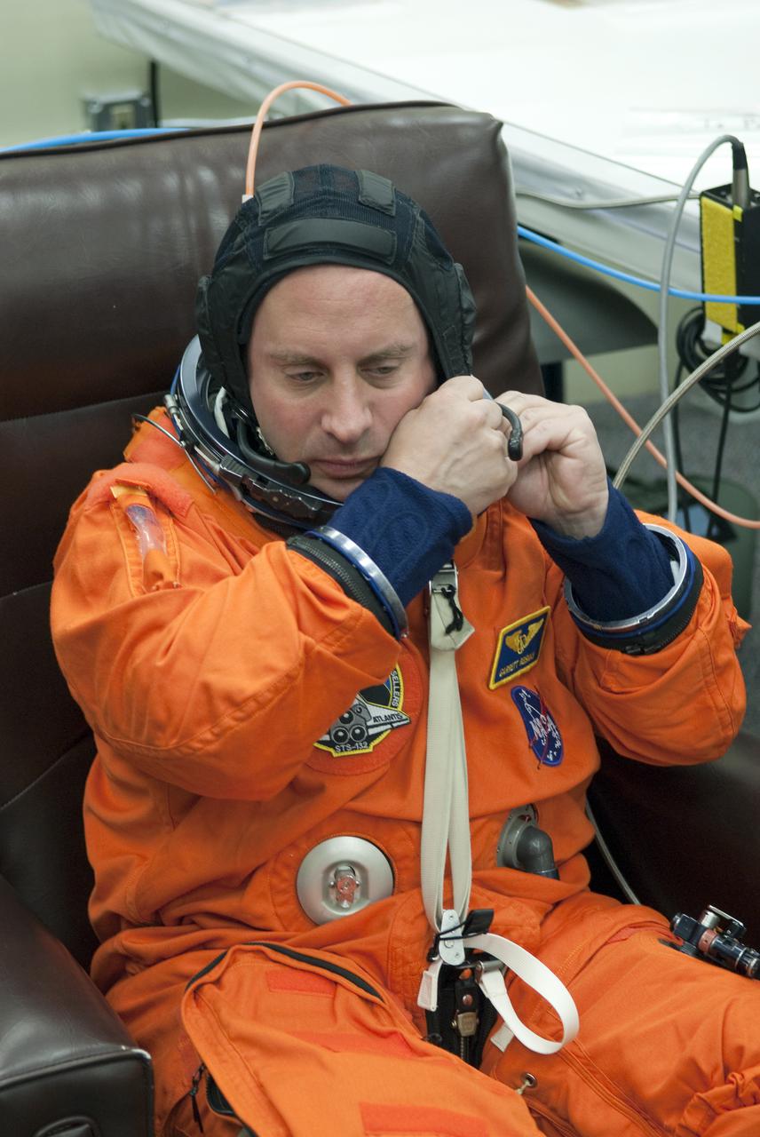 CAPE CANAVERAL, Fla. - In the Operations and Checkout Building at NASA's Kennedy Space Center in Florida, STS-132 Mission Specialist Garrett Reisman prepares to put on his space suit's helmet. Reisman was a flight engineer on the International Space Station's Expedition 16 and 17. The six-member STS-132 crew is at Kennedy for their Terminal Countdown Demonstration Test, or TCDT, a dress rehearsal for launch. Following this practice 'suit-up,' the astronauts will ride in the Astrovan to Launch Pad 39A where they will participate in a simulated launch countdown from their seats inside space shuttle Atlantis. Launch is targeted for 2:19 p.m. EDT on May 14. On the STS-132 mission, the crew will deliver an Integrated Cargo Carrier, or ICC, and the Russian-built Mini-Research Module-1, or MRM-1, to the International Space Station. The ICC is an unpressurized flat bed pallet and keel yoke assembly used to support the transfer of exterior cargo from the shuttle to the space station. The MRM-1, known as Rassvet, is the second in a series of new pressurized components for Russia and will be permanently attached to the Earth-facing port of the Zarya control module. Rassvet, which translates to 'dawn,' will be used for cargo storage and provide an additional docking port to the station. STS-132 is the 34th mission to the station and the 132nd shuttle mission overall. For information on the STS-132 mission, visit http:__www.nasa.gov_mission_pages_shuttle_shuttlemissions_sts132_index.html. Photo credit: NASA_Cory Huston