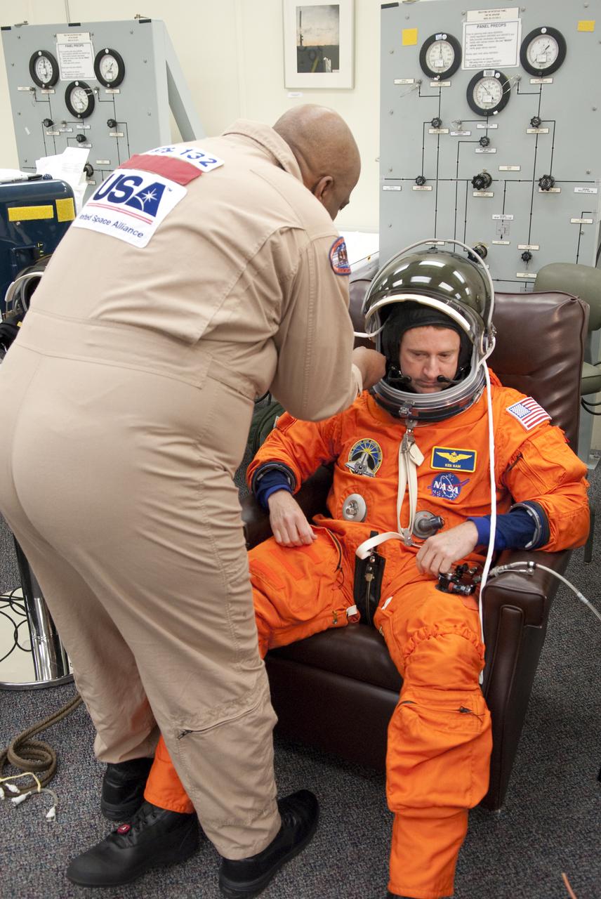 CAPE CANAVERAL, Fla. - In the Operations and Checkout Building at NASA's Kennedy Space Center in Florida, a United Launch Alliance space suit technician assists STS-132 Commander Ken Ham with the connections to his suit's helmet. STS-132 is Ham's second spaceflight. The six-member STS-132 crew is at Kennedy for their Terminal Countdown Demonstration Test, or TCDT, a dress rehearsal for launch. Following this practice 'suit-up,' the astronauts will ride in the Astrovan to Launch Pad 39A where they will participate in a simulated launch countdown from their seats inside space shuttle Atlantis. Launch is targeted for 2:19 p.m. EDT on May 14. On the STS-132 mission, the crew will deliver an Integrated Cargo Carrier, or ICC, and the Russian-built Mini-Research Module-1, or MRM-1, to the International Space Station. The ICC is an unpressurized flat bed pallet and keel yoke assembly used to support the transfer of exterior cargo from the shuttle to the space station. The MRM-1, known as Rassvet, is the second in a series of new pressurized components for Russia and will be permanently attached to the Earth-facing port of the Zarya control module. Rassvet, which translates to 'dawn,' will be used for cargo storage and provide an additional docking port to the station. STS-132 is the 34th mission to the station and the 132nd shuttle mission overall. For information on the STS-132 mission, visit http:__www.nasa.gov_mission_pages_shuttle_shuttlemissions_sts132_index.html. Photo credit: NASA_Cory Huston