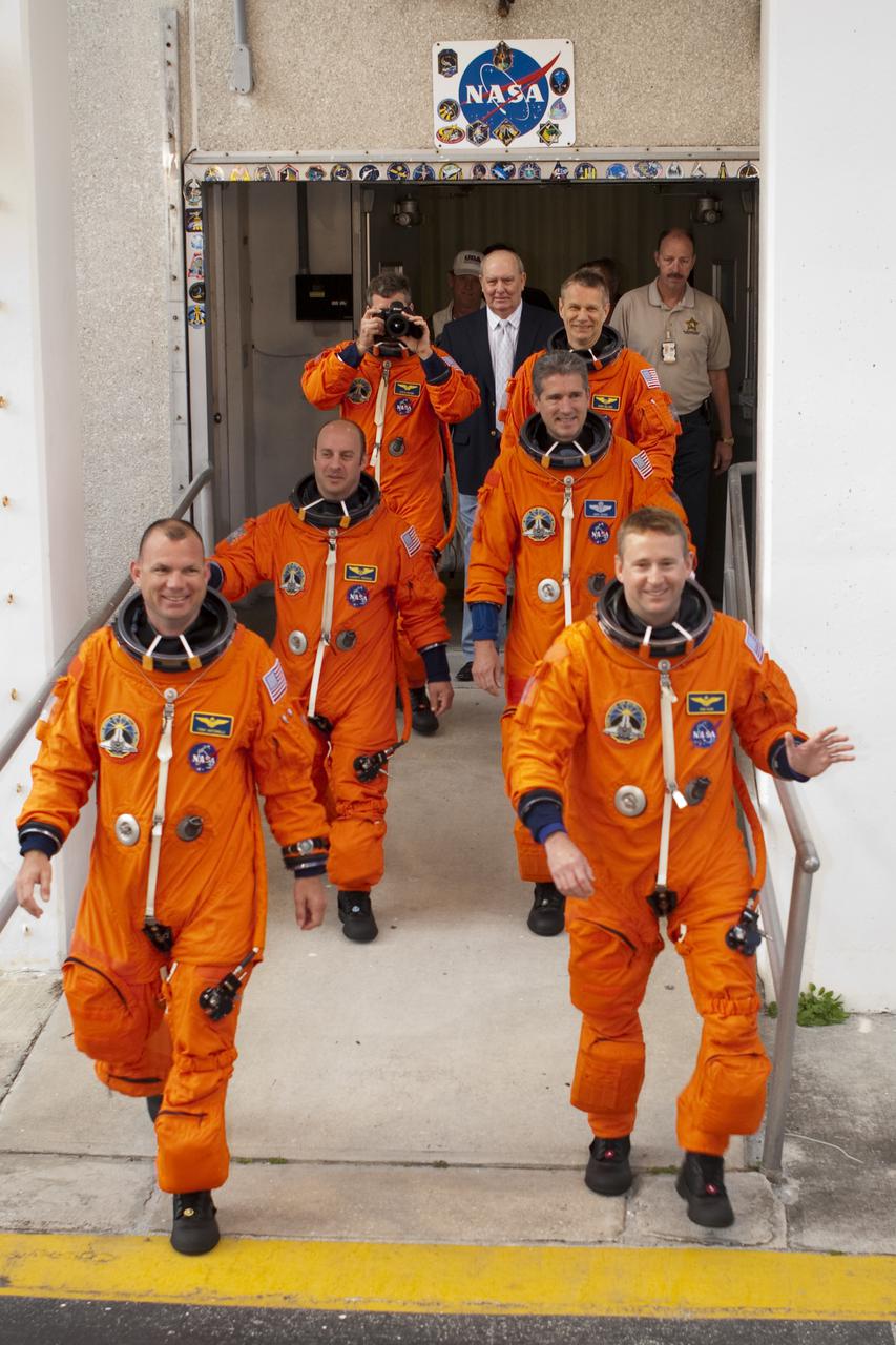 CAPE CANAVERAL, Fla. - At NASA's Kennedy Space Center in Florida, the crew of space shuttle Atlantis' STS-132 mission, dressed in their orange launch-and-entry suits, are greeted by employees and media representatives on hand as they depart from crew quarters in the Operations and Checkout Building. In the left row, from front, are Pilot Tony Antonelli followed by Mission Specialists Garrett Reisman and Steve Bowen, who is capturing the moment with his own camera. In the right row, from front, are Commander Ken Ham followed by Mission Specialists Michael Good and Piers Sellers. This dress rehearsal for launch is known as the Terminal Countdown Demonstration Test, or TCDT. Following this practice 'walkout,' the astronauts will ride in the Astrovan to Launch Pad 39A where they will participate in a simulated launch countdown from their seats inside the crew compartment of space shuttle Atlantis. Launch is targeted for 2:19 p.m. EDT on May 14. On the STS-132 mission, the crew will deliver an Integrated Cargo Carrier, or ICC, and the Russian-built Mini-Research Module-1, or MRM-1, to the International Space Station. The ICC is an unpressurized flat bed pallet and keel yoke assembly used to support the transfer of exterior cargo from the shuttle to the space station. The MRM-1, known as Rassvet, is the second in a series of new pressurized components for Russia and will be permanently attached to the Earth-facing port of the Zarya control module. Rassvet, which translates to 'dawn,' will be used for cargo storage and provide an additional docking port to the station. STS-132 is the 34th mission to the station and the 132nd shuttle mission overall. For information on the STS-132 mission, visit http:__www.nasa.gov_mission_pages_shuttle_shuttlemissions_sts132_index.html. Photo credit: NASA_Cory Huston