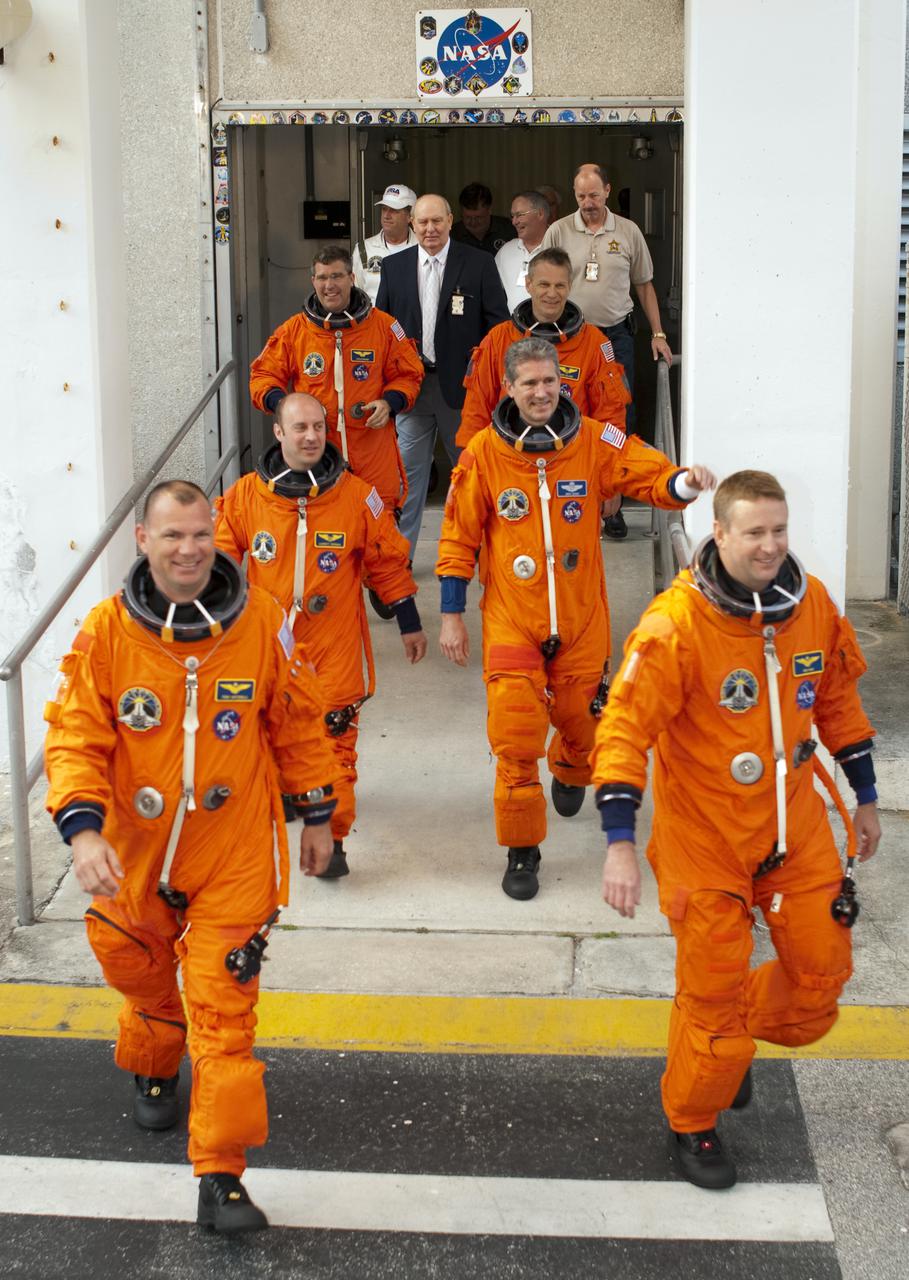 CAPE CANAVERAL, Fla. - At NASA's Kennedy Space Center in Florida, the crew of space shuttle Atlantis' STS-132 mission, dressed in their orange launch-and-entry suits, are cheered on by employees and media representatives on hand as they depart from crew quarters in the Operations and Checkout Building. In the left row, from front, are Pilot Tony Antonelli followed by Mission Specialists Garrett Reisman and Steve Bowen. In the right row, from front, are Commander Ken Ham followed by Mission Specialists Michael Good and Piers Sellers. This dress rehearsal for launch is known as the Terminal Countdown Demonstration Test, or TCDT. Following this practice 'walkout,' the astronauts will ride in the Astrovan to Launch Pad 39A where they will participate in a simulated launch countdown from their seats inside the crew compartment of space shuttle Atlantis. Launch is targeted for 2:19 p.m. EDT on May 14. On the STS-132 mission, the crew will deliver an Integrated Cargo Carrier, or ICC, and the Russian-built Mini-Research Module-1, or MRM-1, to the International Space Station. The ICC is an unpressurized flat bed pallet and keel yoke assembly used to support the transfer of exterior cargo from the shuttle to the space station. The MRM-1, known as Rassvet, is the second in a series of new pressurized components for Russia and will be permanently attached to the Earth-facing port of the Zarya control module. Rassvet, which translates to 'dawn,' will be used for cargo storage and provide an additional docking port to the station. STS-132 is the 34th mission to the station and the 132nd shuttle mission overall. For information on the STS-132 mission, visit http:__www.nasa.gov_mission_pages_shuttle_shuttlemissions_sts132_index.html. Photo credit: NASA_Cory Huston