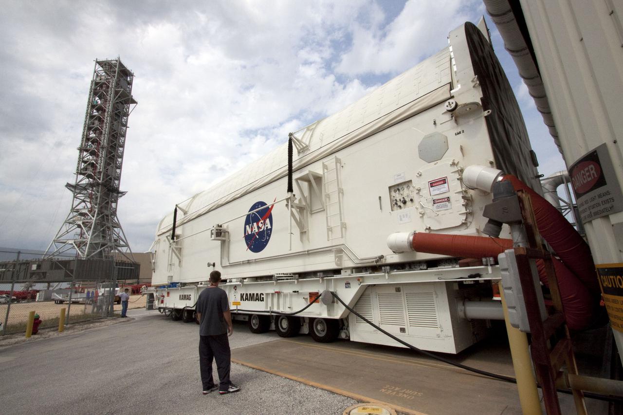 CAPE CANAVERAL, Fla. - At NASA's Kennedy Space Center in Florida, the payload canister containing the multi-purpose logistics module Leonardo and an ammonia tank assembly, removed from space shuttle Discovery's payload bay in Orbiter Processing Facility-3, begins its move to the Space Station Processing Facility.  At left is NASA's new 355-foot-tall mobile launcher.  Discovery landed on Runway 33 at Kennedy's Shuttle Landing Facility at 9:08 a.m. EDT April 20 after 15 days in space, completing the more than 6.2-million-mile STS-131 mission on orbit 238.  The seven-member STS-131 crew carried the multi-purpose logistics module Leonardo, filled with supplies, a new crew sleeping quarters and science racks that were transferred to the International Space Station's laboratories.  Leonardo now will be modified into a permanent multi-purpose module, or PMM, and left aboard the station on space shuttle Discovery's STS-133 mission, targeted for launch Sept. 16.  For information on the STS-131 mission, visit http:__www.nasa.gov_mission_pages_shuttle_shuttlemissions_sts131_index.html.  For information on the STS-133 mission, visit http:__www.nasa.gov_mission_pages_shuttle_shuttlemissions_sts133_index.html.  Photo credit: NASA_Jack Pfaller