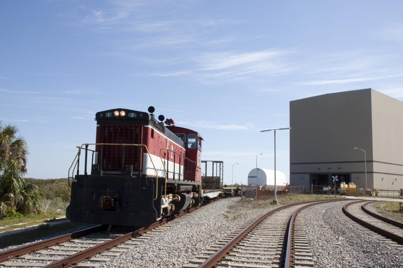 CAPE CANAVERAL, Fla. – Secured inside a railway car, a nozzle exit cone for a solid rocket booster that will be used on space shuttle Discovery's STS-133 mission is moved by locomotive no. 2 to the Rotation, Processing and Surge Facility at NASA's Kennedy Space Center in Florida.  The boosters are manufactured by Alliant Techsystems Inc., or ATK.  EGandG_URS runs Kennedy's railway system for NASA.  The locomotive, one of three at Kennedy, will push the railway car into the facility, necessitating the use of spacer cars behind the locomotive as a safety measure.  Photo credit: NASA_Troy Cryder