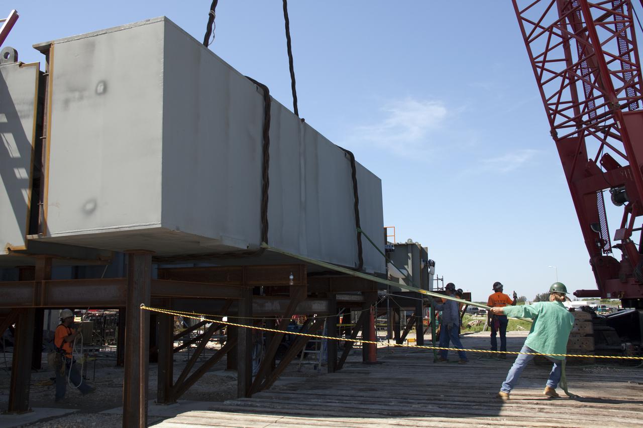 CAPE CANAVERAL, Fla. – At NASA's Kennedy Space Center in Florida, the fourth segment of the launch mount for a new mobile launcher, or ML, being constructed to support NASA's future human spaceflight program, is positioned next to the other segments which have arrived. The construction is taking place in the mobile launcher park site north of Kennedy's Vehicle Assembly Building. The new launcher is 355 feet tall and has multiple platforms for personnel access. The base of the launcher is lighter than space shuttle mobile launcher platforms so the crawler-transporter can pick up the heavier load of the tower and a taller rocket. For information on NASA's future plans, visit http:__www.nasa.gov. Photo credit: NASA_Troy Cryder