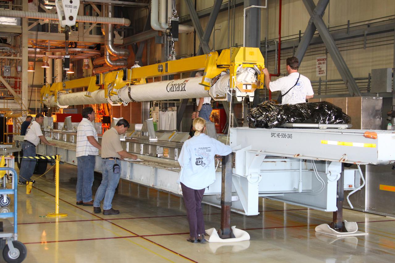 CAPE CANAVERAL, Fla. - In Orbiter Processing Facility-3 at NASA's Kennedy Space Center in Florida, the orbiter boom sensor system, or OBSS, removed from space shuttle Discovery's payload bay, is lowered onto a transporter. The 50-foot-long OBSS attaches to the end of the shuttle’s robotic arm and supports the cameras and laser systems used to inspect the shuttle’s thermal protection system while in space. The OBSS' inspection boom assembly, or IBA, is removed from the arm every other processing flow for a detailed inspection. After five consecutive flights, all IBA internal components are submitted to a thorough electrical checkout in Kennedy's Remote Manipulator System Lab. Discovery next will deliver the first Permanent Multi-purpose Module, or PMM; the Express Logistics Carrier 4; and critical spare parts to the International Space Station on the STS-133 mission. Launch is targeted for Sept. 16. Photo credit: NASA_Jack Pfaller