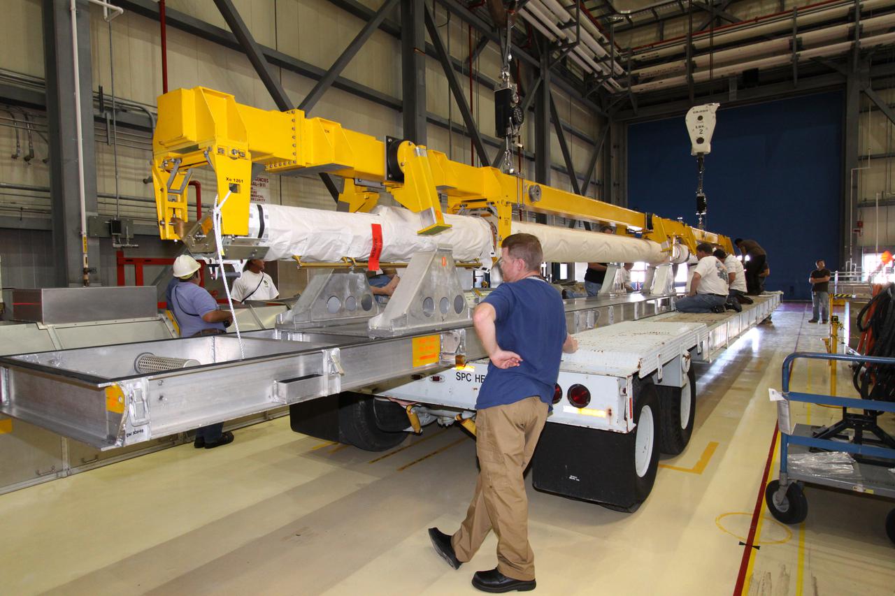 CAPE CANAVERAL, Fla. - In Orbiter Processing Facility-3 at NASA's Kennedy Space Center in Florida, the orbiter boom sensor system, or OBSS, removed from space shuttle Discovery's payload bay, is secured on a transporter. The 50-foot-long OBSS attaches to the end of the shuttle’s robotic arm and supports the cameras and laser systems used to inspect the shuttle’s thermal protection system while in space. The OBSS' inspection boom assembly, or IBA, is removed from the arm every other processing flow for a detailed inspection. After five consecutive flights, all IBA internal components are submitted to a thorough electrical checkout in Kennedy's Remote Manipulator System Lab. Discovery next will deliver the first Permanent Multi-purpose Module, or PMM; the Express Logistics Carrier 4; and critical spare parts to the International Space Station on the STS-133 mission. Launch is targeted for Sept. 16. Photo credit: NASA_Jack Pfaller