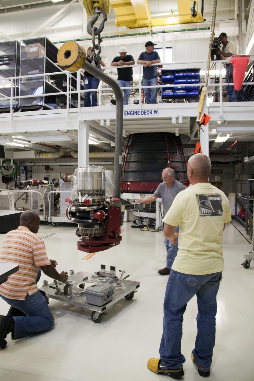 CAPE CANAVERAL, Fla. – On the floor of the Space Shuttle Main Engine Processing Facility at NASA's Kennedy Space Center in Florida, Pratt and Whitney Rocketdyne engine technicians lift a high pressure oxidizer turbo pump off its stand for installation on space shuttle main engine no. 2062. The engine, or SSME, is the last one scheduled to be built at Kennedy by Pratt and Whitney Rocketdyne before the end of the Space Shuttle Program. From left are Teryon Jones, Dan Bode and Ryan Mahony. Three main engines are clustered at the aft end of the shuttle and have a combined thrust of more than 1.2 million pounds. Even though an SSME weighs one-seventh as much as a locomotive engine, its high-pressure fuel pump alone delivers as much horsepower as 28 locomotives. Each engine operates during the entire eight-and-a-half minute climb to orbit. Post-flight inspections and maintenance of each engine also are conducted in the SSME Processing Facility between shuttle missions. Photo credit: NASA_Amanda Diller