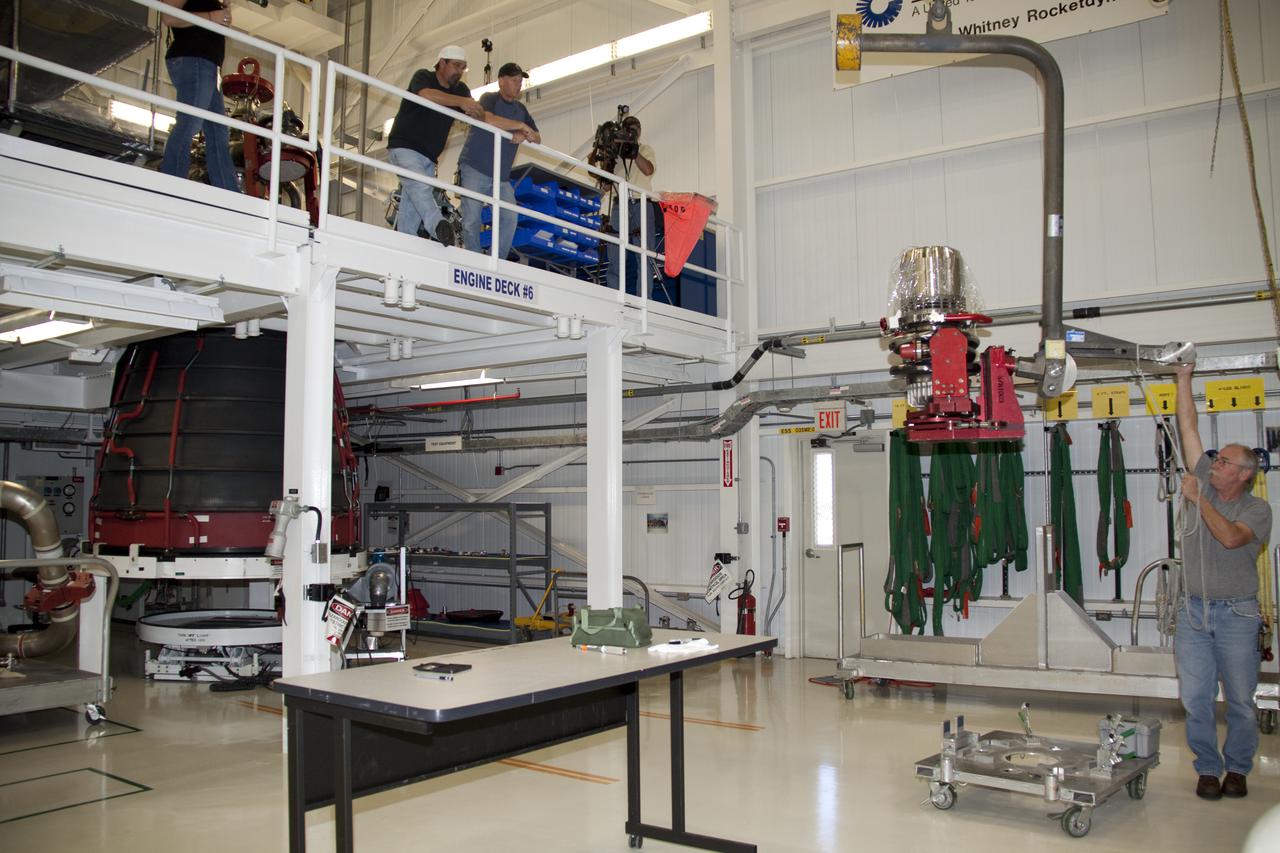 CAPE CANAVERAL, Fla. – On the floor of the Space Shuttle Main Engine Processing Facility at NASA's Kennedy Space Center in Florida, Pratt and Whitney Rocketdyne engine technician Dan Bode lifts a high pressure oxidizer turbo pump off its stand for installation on space shuttle main engine no. 2062. The engine, or SSME, is the last one scheduled to be built at Kennedy by Pratt and Whitney Rocketdyne before the end of the Space Shuttle Program. Three main engines are clustered at the aft end of the shuttle and have a combined thrust of more than 1.2 million pounds. Even though an SSME weighs one-seventh as much as a locomotive engine, its high-pressure fuel pump alone delivers as much horsepower as 28 locomotives. Each engine operates during the entire eight-and-a-half minute climb to orbit. Post-flight inspections and maintenance of each engine also are conducted in the SSME Processing Facility between shuttle missions. Photo credit: NASA_Amanda Diller