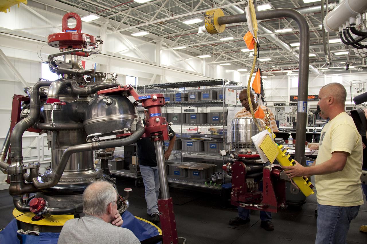 CAPE CANAVERAL, Fla. – In the Space Shuttle Main Engine Processing Facility at NASA's Kennedy Space Center in Florida, Pratt and Whitney Rocketdyne engine technicians prepare to install a high pressure oxidizer turbo pump on space shuttle main engine no. 2062.  The engine, or SSME, is the last one scheduled to be built at Kennedy before the end of the Space Shuttle Program.  From left are Dan Bode, Teryon Jones, and Ryan Mahony.  Quality inspector Barry Martin is standing beside the engine, just out of view.  Three main engines are clustered at the aft end of the shuttle and have a combined thrust of more than 1.2 million pounds.  Even though an SSME weighs one-seventh as much as a locomotive engine, its high-pressure fuel pump alone delivers as much horsepower as 28 locomotives.  Each engine operates during the entire eight-and-a-half minute climb to orbit.  Post-flight inspections and maintenance of each engine also are conducted in the SSME Processing Facility between shuttle missions.  Photo credit: NASA_Amanda Diller