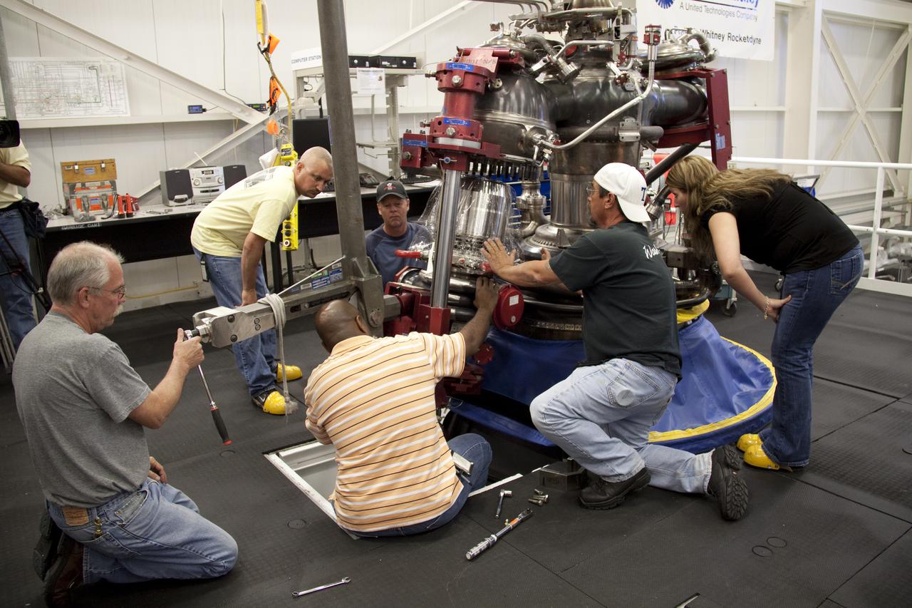 CAPE CANAVERAL, Fla. – In the Space Shuttle Main Engine Processing Facility at NASA's Kennedy Space Center in Florida, Pratt and Whitney Rocketdyne engine technicians install a high pressure oxidizer turbo pump on space shuttle main engine no. 2062.  The engine, or SSME, is the last one scheduled to be built at Kennedy before the end of the Space Shuttle Program.  In front of the engine, from left, are Dan Bode, Teryon Jones, quality inspector Barry Martin, and engineer Jessica Tandy.  Behind the engine, from left, are Ryan Mahony and Ken Burley.  Three main engines are clustered at the aft end of the shuttle and have a combined thrust of more than 1.2 million pounds.  Even though an SSME weighs one-seventh as much as a locomotive engine, its high-pressure fuel pump alone delivers as much horsepower as 28 locomotives.  Each engine operates during the entire eight-and-a-half minute climb to orbit.  Post-flight inspections and maintenance of each engine also are conducted in the SSME Processing Facility between shuttle missions.  Photo credit: NASA_Amanda Diller