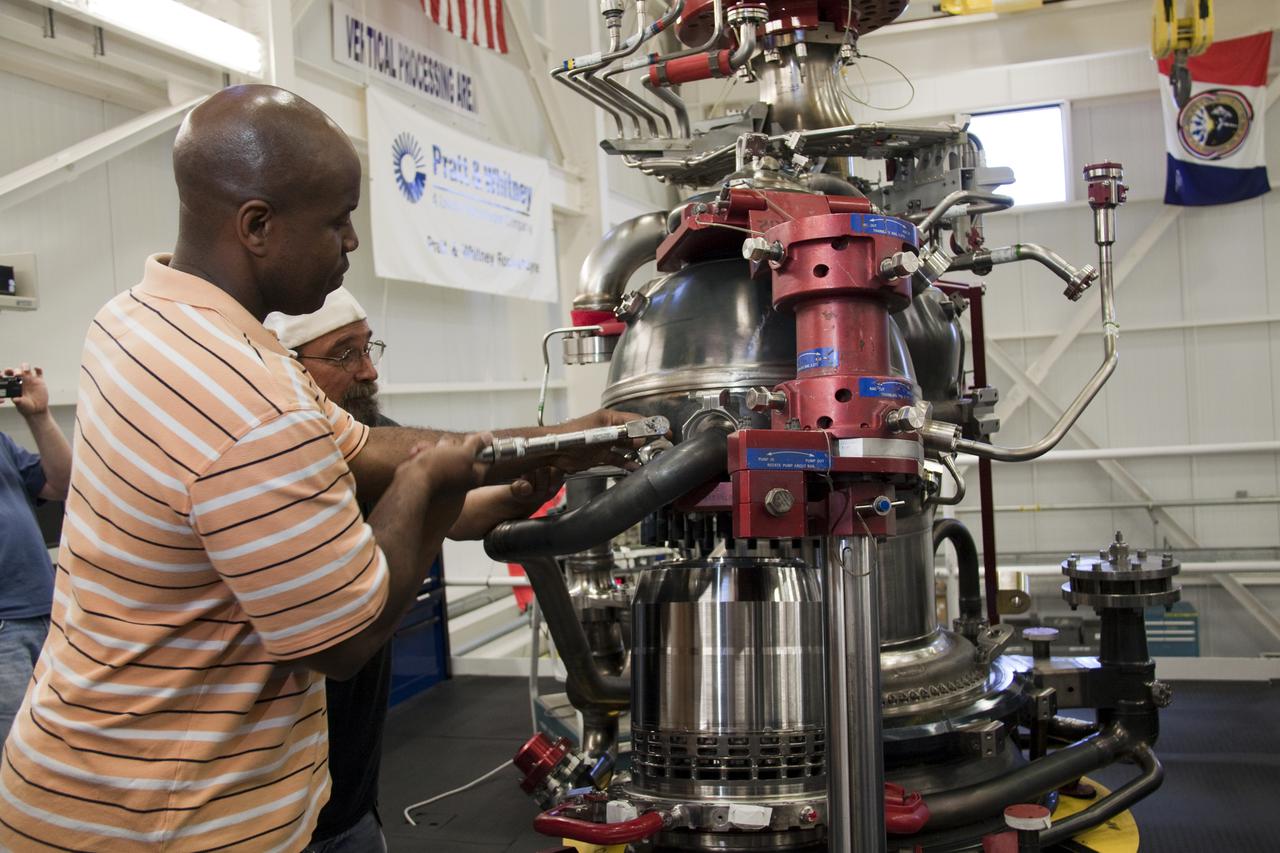 CAPE CANAVERAL, Fla. – In the Space Shuttle Main Engine Processing Facility at NASA's Kennedy Space Center in Florida, Pratt and Whitney Rocketdyne engine technician Teryon Jones, left, and quality inspector Barry Martin install a high pressure oxidizer turbo pump on space shuttle main engine no. 2062.  The engine, or SSME, is the last one scheduled to be built at Kennedy before the end of the Space Shuttle Program.  Three main engines are clustered at the aft end of the shuttle and have a combined thrust of more than 1.2 million pounds.  Even though an SSME weighs one-seventh as much as a locomotive engine, its high-pressure fuel pump alone delivers as much horsepower as 28 locomotives.  Each engine operates during the entire eight-and-a-half minute climb to orbit.  Post-flight inspections and maintenance of each engine also are conducted in the SSME Processing Facility between shuttle missions.  Photo credit: NASA_Amanda Diller
