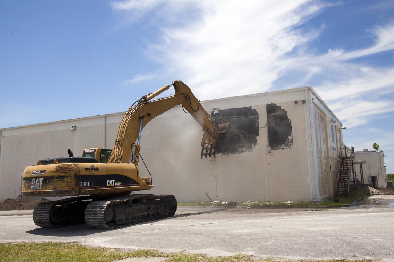 CAPE CANAVERAL, Fla. – At Cape Canaveral Air Force Station in Florida, a Caterpillar 330 track-hoe punches a hole in the wall of the Mercury Mission Control Center.  The original building, constructed between 1956 and 1958, was last modified in 1963.  The center succumbed to the two worst enemies of structures along the space coast - time and salt air - necessitating that it be demolished as a safety measure.  The facility served as mission control during all the Project Mercury missions, as well as the first three flights of the Gemini Program. The center housed the flight controllers whose duty was to take over flight control after liftoff and follow it through until splashdown. Additionally, it supported vehicle checkout, spacecraft tracking, and astronaut training. With Gemini IV, mission control moved to Houston, and the facility took on the roles of launch control and tracking station. In 1999, much of the equipment and furnishings from the flight control area was moved to Kennedy Space Center's Visitor Complex.  A re-created mission control room currently is on display in the complex's Dr. Kurt H. Debus Conference Facility.  Speegle II of Cocoa, Fla., was awarded the contract for the deconstruction project.  Frank-Lin Excavating is performing the demolition for Sunrise Systems of Brevard, a subcontractor to Speegle II.  Photo credit: NASA_Jack Pfaller