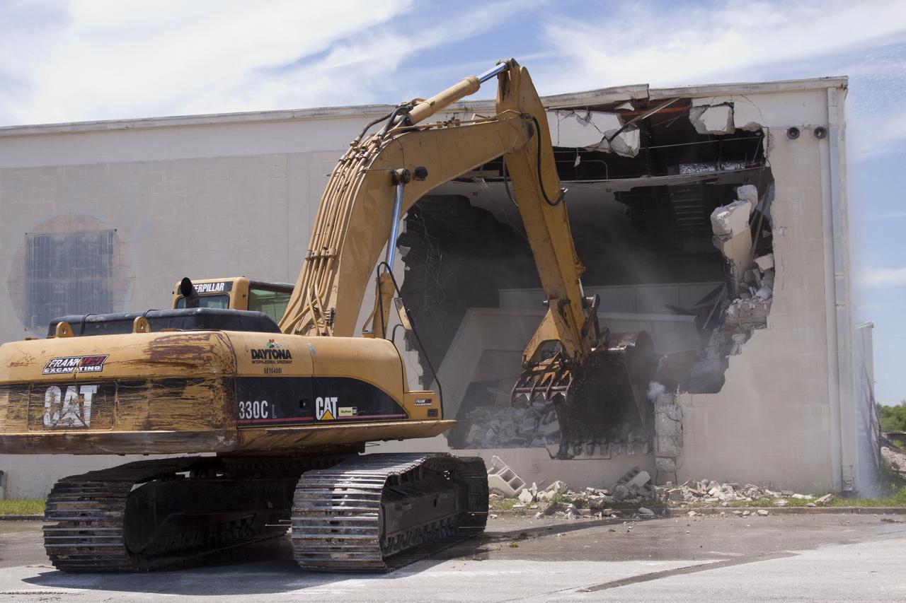 CAPE CANAVERAL, Fla. – At Cape Canaveral Air Force Station in Florida, a Caterpillar 330 track-hoe knocks down the Mercury Mission Control Center.  The original building, constructed between 1956 and 1958, was last modified in 1963.  The center succumbed to the two worst enemies of structures along the space coast - time and salt air - necessitating that it be demolished as a safety measure.  The facility served as mission control during all the Project Mercury missions, as well as the first three flights of the Gemini Program. The center housed the flight controllers whose duty was to take over flight control after liftoff and follow it through until splashdown. Additionally, it supported vehicle checkout, spacecraft tracking, and astronaut training. With Gemini IV, mission control moved to Houston, and the facility took on the roles of launch control and tracking station. In 1999, much of the equipment and furnishings from the flight control area was moved to Kennedy Space Center's Visitor Complex.  A re-created mission control room currently is on display in the complex's Dr. Kurt H. Debus Conference Facility.  Speegle II of Cocoa, Fla., was awarded the contract for the deconstruction project.  Frank-Lin Excavating is performing the demolition for Sunrise Systems of Brevard, a subcontractor to Speegle II.  Photo credit: NASA_Jack Pfaller