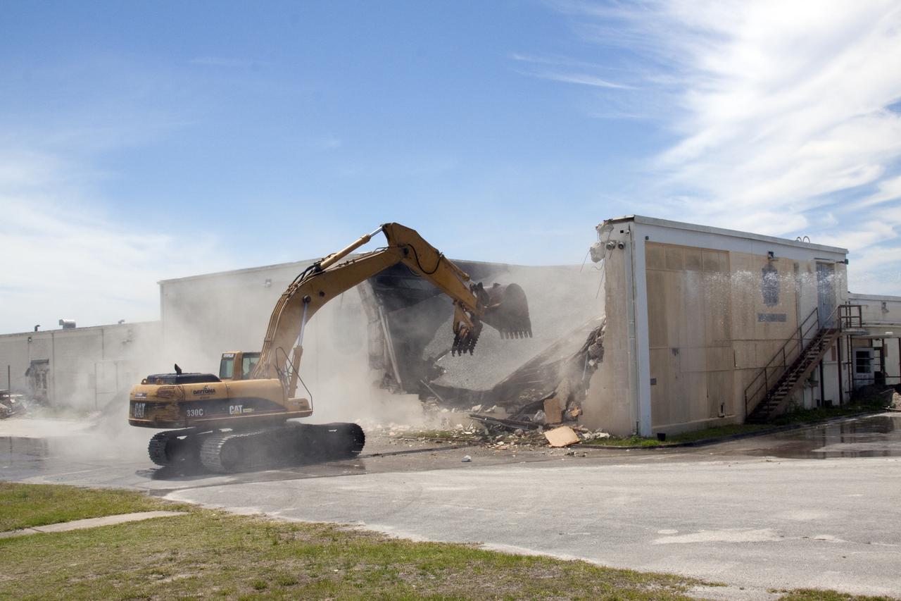 CAPE CANAVERAL, Fla. – At Cape Canaveral Air Force Station in Florida, a Caterpillar 330 track-hoe turns the Mercury Mission Control Center into a pile of rubble.  The original building, constructed between 1956 and 1958, was last modified in 1963.  The center succumbed to the two worst enemies of structures along the space coast - time and salt air - necessitating that it be demolished as a safety measure.  The facility served as mission control during all the Project Mercury missions, as well as the first three flights of the Gemini Program. The center housed the flight controllers whose duty was to take over flight control after liftoff and follow it through until splashdown. Additionally, it supported vehicle checkout, spacecraft tracking, and astronaut training. With Gemini IV, mission control moved to Houston, and the facility took on the roles of launch control and tracking station. In 1999, much of the equipment and furnishings from the flight control area was moved to Kennedy Space Center's Visitor Complex.  A re-created mission control room currently is on display in the complex's Dr. Kurt H. Debus Conference Facility.  Speegle II of Cocoa, Fla., was awarded the contract for the deconstruction project.  Frank-Lin Excavating is performing the demolition for Sunrise Systems of Brevard, a subcontractor to Speegle II.  Photo credit: NASA_Jack Pfaller