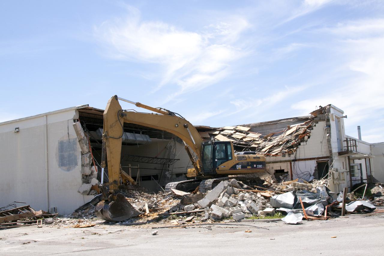 CAPE CANAVERAL, Fla. – At Cape Canaveral Air Force Station in Florida, the walls of the Mercury Mission Control Center tumble down under the careful guidance of a Caterpillar 330 track-hoe.  The original building, constructed between 1956 and 1958, was last modified in 1963.  The center succumbed to the two worst enemies of structures along the space coast - time and salt air - necessitating that it be demolished as a safety measure.  The facility served as mission control during all the Project Mercury missions, as well as the first three flights of the Gemini Program. The center housed the flight controllers whose duty was to take over flight control after liftoff and follow it through until splashdown. Additionally, it supported vehicle checkout, spacecraft tracking, and astronaut training. With Gemini IV, mission control moved to Houston, and the facility took on the roles of launch control and tracking station. In 1999, much of the equipment and furnishings from the flight control area was moved to Kennedy Space Center's Visitor Complex.  A re-created mission control room currently is on display in the complex's Dr. Kurt H. Debus Conference Facility.  Speegle II of Cocoa, Fla., was awarded the contract for the deconstruction project.  Frank-Lin Excavating is performing the demolition for Sunrise Systems of Brevard, a subcontractor to Speegle II.  Photo credit: NASA_Jack Pfaller