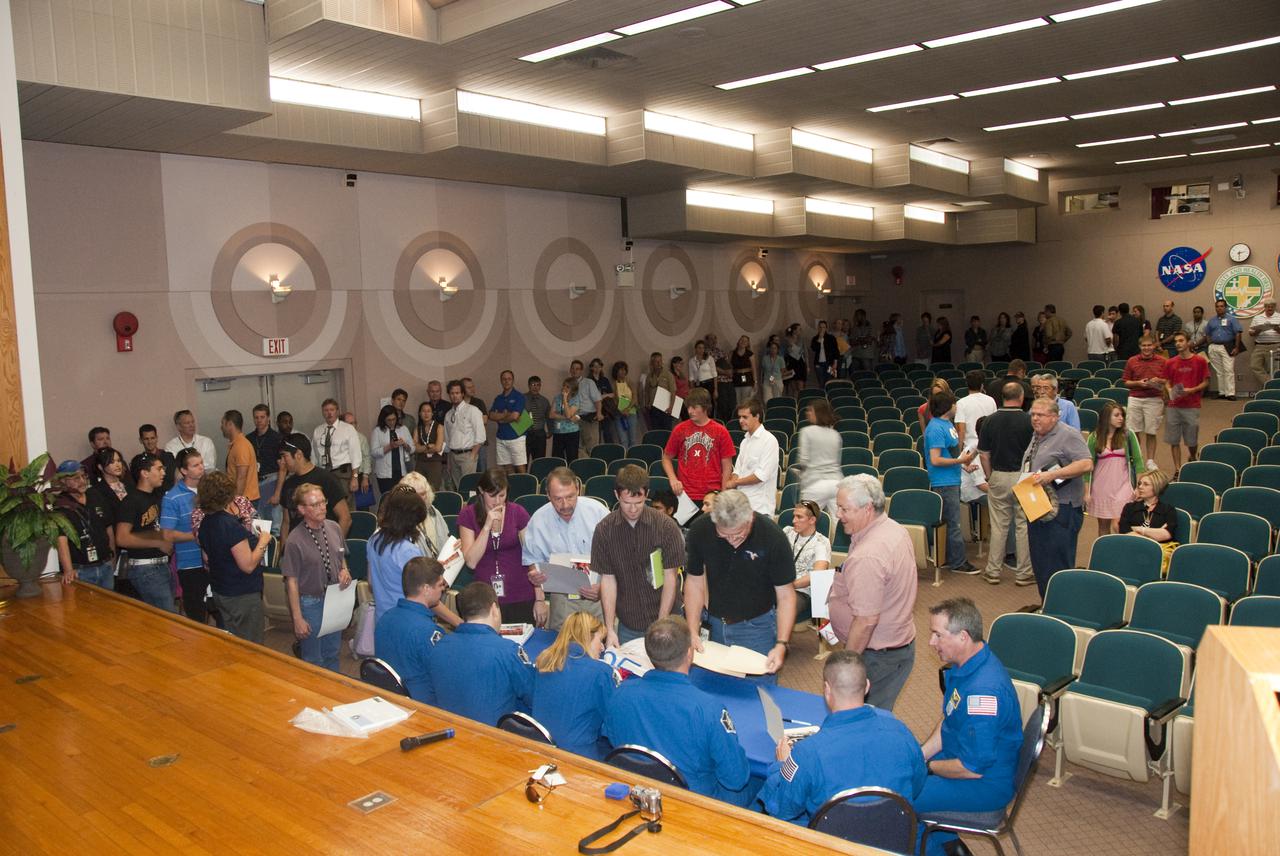 CAPE CANAVERAL, Fla. - In the Training Auditorium at NASA's Kennedy Space Center in Florida, Kennedy employees wait their turns to receive the autographs of space shuttle Endeavour's STS-130 crew members.  In the blue flight suits, seated from left, are Mission Specialists Robert Behnken, Nicholas Patrick and Kathryn Hire; Pilot Terry Virts; Commander George Zamka; and Mission Specialist Stephen Robinson.  The autograph-signing session followed a program for Kennedy employees in which the crew talked about their experiences on the mission.  Endeavour launched Feb. 8, 2010, and landed Feb. 21.  During Endeavour's STS-130 mission, the crew installed the Tranquility node, a module that provides additional room for crew members and many of the station's life support and environmental control systems. Attached to Tranquility is a cupola with seven windows that provide a panoramic view of Earth, celestial objects and visiting spacecraft. STS-130 was the 24th flight for Endeavour, the 32nd shuttle mission devoted to ISS assembly and maintenance, and the 130th shuttle mission.  For information on the STS-130 mission and crew, visit http:__www.nasa.gov_mission_pages_shuttle_shuttlemissions_sts130_index.html.  Photo credit: NASA_Jim Grossmann