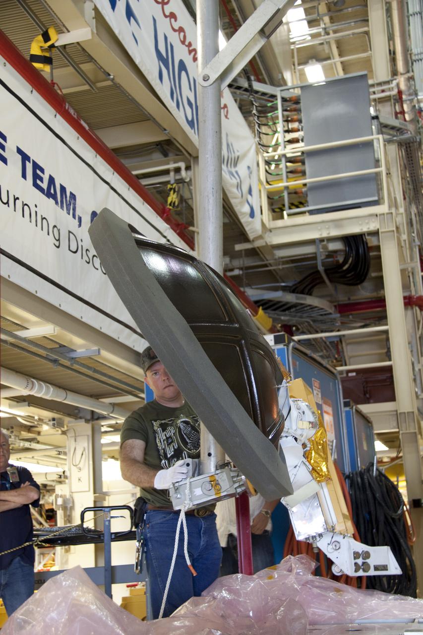 CAPE CANAVERAL, Fla. -- Technicians prepare to install a new Ku-Band communications system antenna on space shuttle Discovery in Orbiter Processing Facility-3 at NASA's Kennedy Space Center in Florida. The antenna is used to transmit and receive high data rate communications, such as video, and is being replaced for the STS-133 mission to the International Space Station. During its STS-131 mission to the station in April, Discovery's Ku-Band failed to operate in orbit. As a result, video of the thermal protection system inspection had to be recorded aboard Discovery and transmitted to the ground after the shuttle docked with the station. Typically, the inspection video is simultaneously transmitted live to the ground and recorded aboard the shuttle for later review. NASA_Charisse Nahser