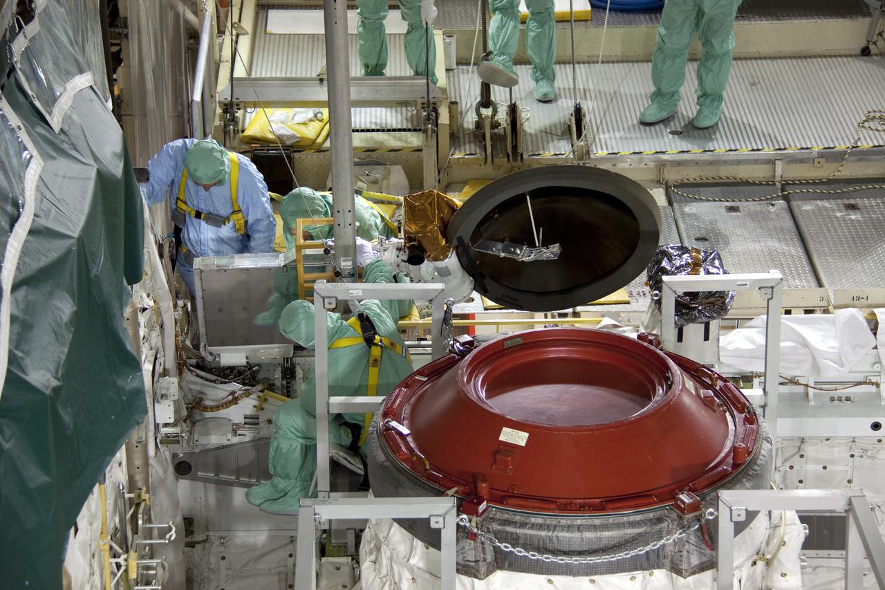 CAPE CANAVERAL, Fla. -- Technicians install a new Ku-Band communications system antenna on space shuttle Discovery in Orbiter Processing Facility-3 at NASA's Kennedy Space Center in Florida. The antenna is used to transmit and receive high data rate communications, such as video, and is being replaced for the STS-133 mission to the International Space Station.  During its STS-131 mission to the station in April, Discovery's Ku-Band failed to operate in orbit. As a result, video of the thermal protection system inspection had to be recorded aboard Discovery and transmitted to the ground after the shuttle docked with the station. Typically, the inspection video is simultaneously transmitted live to the ground and recorded aboard the shuttle for later review. NASA_Charisse Nahser
