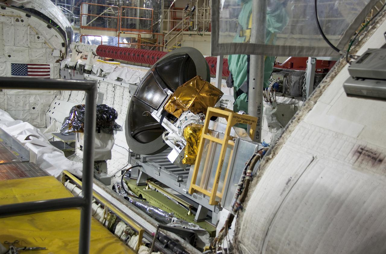 CAPE CANAVERAL, Fla. -- A new Ku-Band communications system antenna is installed on space shuttle Discovery in Orbiter Processing Facility-3 at NASA's Kennedy Space Center in Florida. The antenna is used to transmit and receive high data rate communications, such as video, and is being replaced for the STS-133 mission to the International Space Station.  During its STS-131 mission to the station in April, Discovery's Ku-Band failed to operate in orbit. As a result, video of the thermal protection system inspection had to be recorded aboard Discovery and transmitted to the ground after the shuttle docked with the station. Typically, the inspection video is simultaneously transmitted live to the ground and recorded aboard the shuttle for later review. NASA_Charisse Nahser
