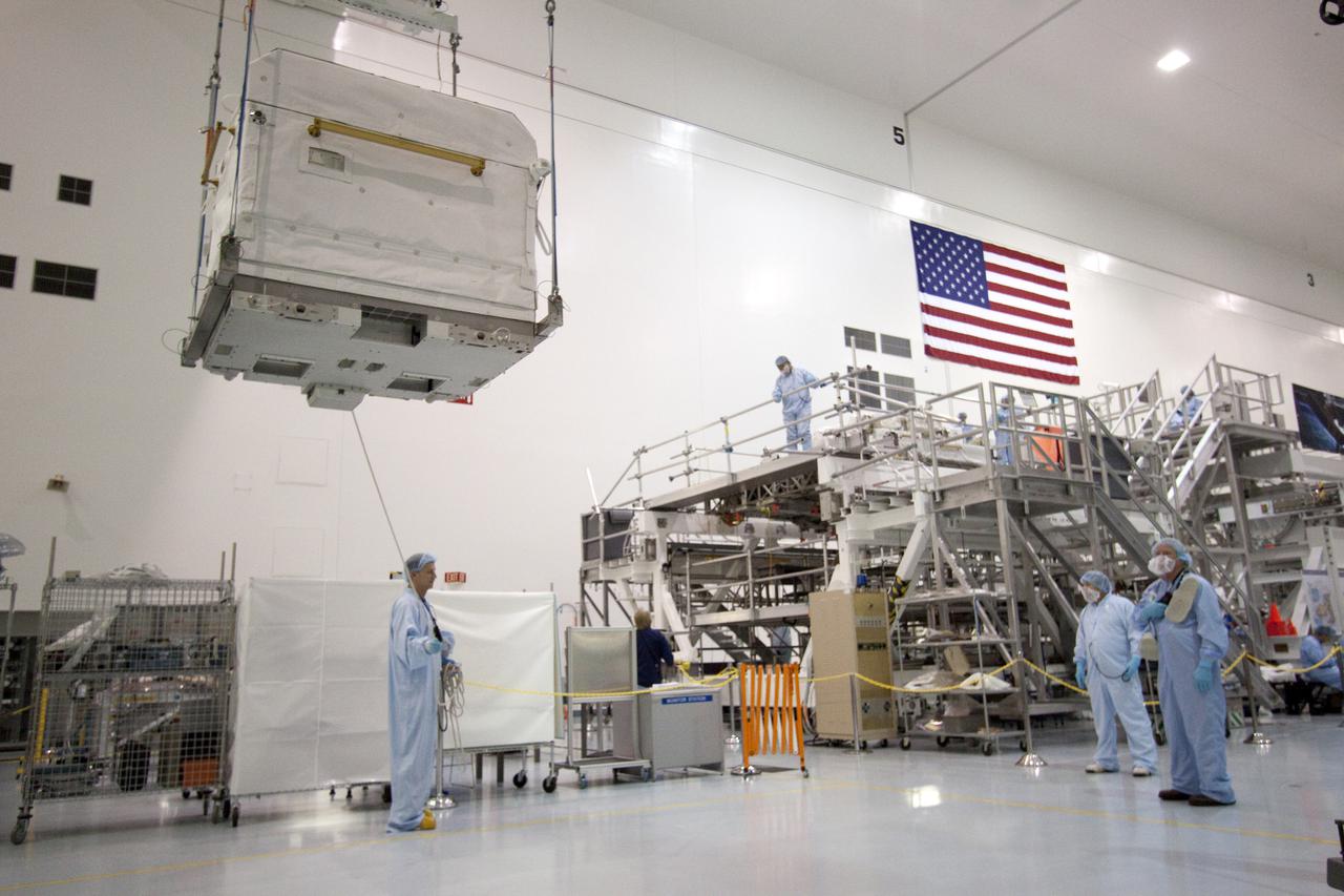 CAPE CANAVERAL, Fla. - In the Space Station Processing Facility at NASA's Kennedy Space Center in Florida, a cargo transport container is lifted off the floor of the clean room. The container is being moved toward the ExPRESS Logistics Carrier-3, or ELC-3, on which it will be installed.  The ELC-3 and the Alpha Magnetic Spectrometer are the primary payloads on space shuttle Endeavour's STS-134 mission to the International Space Station. Spare parts, including two S-band communications antennas; a high pressure gas tank; replacement parts for Dextre, the robotic hand on the station; and micrometeoroid debris shields, also will be delivered to the station.  Endeavour's launch is targeted for mid-November. For information on the STS-134 mission, visit http:__www.nasa.gov_mission_pages_shuttle_shuttlemissions_sts134_index.html. Photo credit: NASA_Jack Pfaller