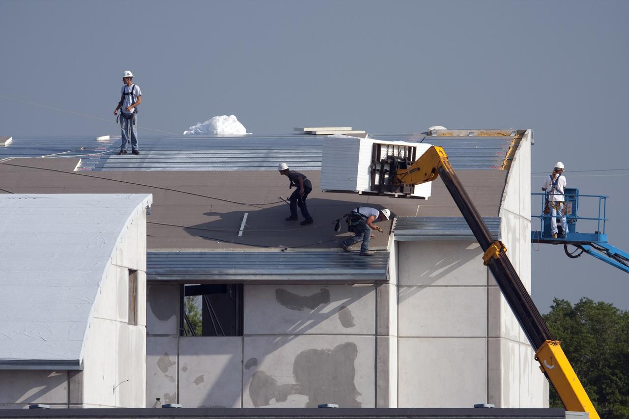 CAPE CANAVERAL, Fla. - At Launch Complex 39 at NASA's Kennedy Space Center in Florida, a boom lift delivers insulation material to the workers installing it on the roof of one of the Propellants North Administrative and Maintenance Facility buildings. The insulation has an R-40 rating, compared to the insulation under the roof of an average home which has a rating of R-10 or R-15. The facility will have a two-story administrative building to house managers, mechanics and technicians who fuel spacecraft at Kennedy adjacent to an 1,800-square-foot single-story shop to store cryogenic fuel transfer equipment. The new facility will feature high-efficiency roofs and walls, “Cool Dry Quiet” air conditioning with energy recovery technology, efficient lighting, and other sustainable features. The facility is striving to qualify for the U.S. Green Building Council’s Leadership in Energy and Environmental Design, or LEED, Platinum certification. If successful, Propellants North will be the first Kennedy facility to achieve this highest of LEED ratings after it is completed in December 2010. The facility was designed for NASA by Jones Edmunds and Associates. H. W. Davis Construction is the construction contractor. Photo credit: NASA_Dimitri Gerondidakis