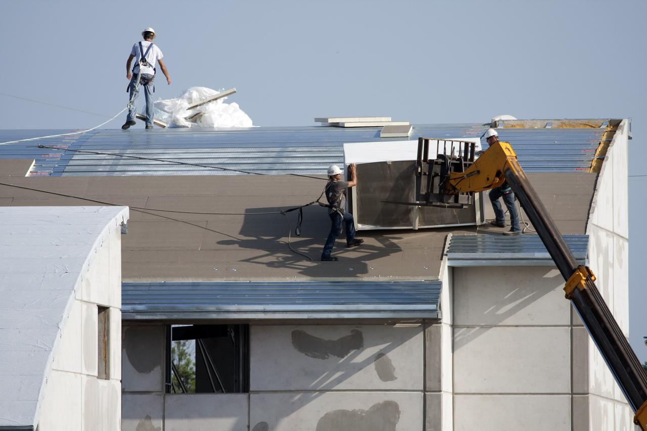 CAPE CANAVERAL, Fla. - At Launch Complex 39 at NASA's Kennedy Space Center in Florida, insulation material is delivered to roofers on one of the Propellants North Administrative and Maintenance Facility buildings by a boom lift. The insulation has an R-40 rating, compared to the insulation under the roof of an average home which has a rating of R-10 or R-15. The facility will have a two-story administrative building to house managers, mechanics and technicians who fuel spacecraft at Kennedy adjacent to an 1,800-square-foot single-story shop to store cryogenic fuel transfer equipment. The new facility will feature high-efficiency roofs and walls, “Cool Dry Quiet” air conditioning with energy recovery technology, efficient lighting, and other sustainable features. The facility is striving to qualify for the U.S. Green Building Council’s Leadership in Energy and Environmental Design, or LEED, Platinum certification. If successful, Propellants North will be the first Kennedy facility to achieve this highest of LEED ratings after it is completed in December 2010. The facility was designed for NASA by Jones Edmunds and Associates. H. W. Davis Construction is the construction contractor. Photo credit: NASA_Dimitri Gerondidakis