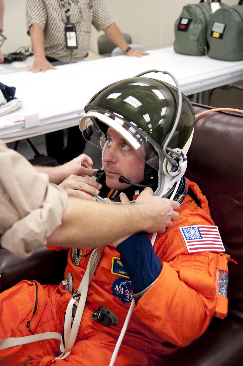 CAPE CANAVERAL, Fla. - In the Operations and Checkout Building at NASA's Kennedy Space Center in Florida, the astronauts of space shuttle Atlantis' STS-132 crew put on their launch-and-entry suits before heading to the Astrovan for the ride to Launch Pad 39A. Mission Specialist Garrett Reisman, seen here checking out his helmet, was a flight engineer on the International Space Station's Expedition 16 and 17.  Liftoff of the STS-132 mission is set for 2:20 p.m. EDT on May 14.  The six-member STS-132 crew will deliver the Russian-built Mini Research Module-1 to the International Space Station.  Named Rassvet, Russian for 'dawn,' the module is the second in a series of new pressurized components for Russia and will be permanently attached to the Earth-facing port of the Zarya control module.  Rassvet will be used for cargo storage and will provide an additional docking port to the station. Also aboard Atlantis is an Integrated Cargo Carrier, or ICC, an unpressurized flat bed pallet and keel yoke assembly used to support the transfer of exterior cargo from the shuttle to the station.  STS-132 is the 34th mission to the station and the last scheduled flight for Atlantis. For more information on the STS-132 mission objectives, payload and crew, visit http:__www.nasa.gov_mission_pages_shuttle_shuttlemissions_sts132_index.html. Photo Credit: NASA_Kim Shiflett