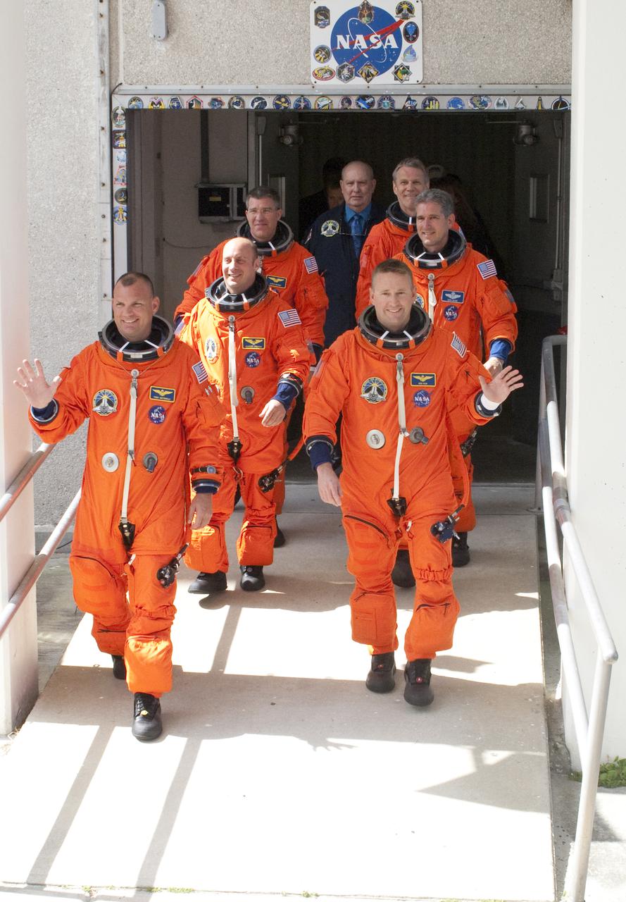 CAPE CANAVERAL, Fla. - At NASA's Kennedy Space Center in Florida, the astronauts on space shuttle Atlantis' STS-132 crew, dressed in their orange launch-and-entry suits, wave to news media representatives and other spectators as they walk out of the Operations and Checkout Building for the ride in the Astrovan to Launch Pad 39A. In the left row, from front, are Pilot Tony Antonelli and Mission Specialists Garrett Reisman and Steve Bowen. In the right row, from front, are Commander Ken Ham and Mission Specialists Michael Good and Piers Sellers. Liftoff of the STS-132 mission is set for 2:20 p.m. EDT on May 14. The six-member STS-132 crew will deliver the Russian-built Mini Research Module-1 to the International Space Station. Named Rassvet, Russian for 'dawn,' the module is the second in a series of new pressurized components for Russia and will be permanently attached to the Earth-facing port of the Zarya control module. Rassvet will be used for cargo storage and will provide an additional docking port to the station. Also aboard Atlantis is an Integrated Cargo Carrier, or ICC, an unpressurized flat bed pallet and keel yoke assembly used to support the transfer of exterior cargo from the shuttle to the station. STS-132 is the 34th mission to the station and the last scheduled flight for Atlantis. For more information on the STS-132 mission objectives, payload and crew, visit http:__www.nasa.gov_mission_pages_shuttle_shuttlemissions_sts132_index.html. Photo Credit: NASA_Kim Shiflett