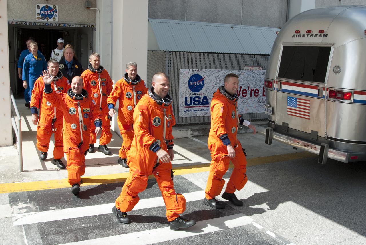 CAPE CANAVERAL, Fla. - At NASA's Kennedy Space Center in Florida, the astronauts on space shuttle Atlantis' STS-132 crew, dressed in their orange launch-and-entry suits, wave to news media representatives and other spectators as they walk out of the Operations and Checkout Building for the ride in the Astrovan to Launch Pad 39A. In the left row, from front, are Pilot Tony Antonelli and Mission Specialists Garrett Reisman and Steve Bowen.  In the right row, from front, are Commander Ken Ham and Mission Specialists Michael Good and Piers Sellers. The white band on Ham's left wrist is a watch protector, which will make putting on his suit's gloves easier.  Liftoff of the STS-132 mission is set for 2:20 p.m. EDT on May 14.  The six-member STS-132 crew will deliver the Russian-built Mini Research Module-1 to the International Space Station.  Named Rassvet, Russian for 'dawn,' the module is the second in a series of new pressurized components for Russia and will be permanently attached to the Earth-facing port of the Zarya control module.  Rassvet will be used for cargo storage and will provide an additional docking port to the station. Also aboard Atlantis is an Integrated Cargo Carrier, or ICC, an unpressurized flat bed pallet and keel yoke assembly used to support the transfer of exterior cargo from the shuttle to the station.  STS-132 is the 34th mission to the station and the last scheduled flight for Atlantis. For more information on the STS-132 mission objectives, payload and crew, visit http:__www.nasa.gov_mission_pages_shuttle_shuttlemissions_sts132_index.html. Photo Credit: NASA_Kim Shiflett