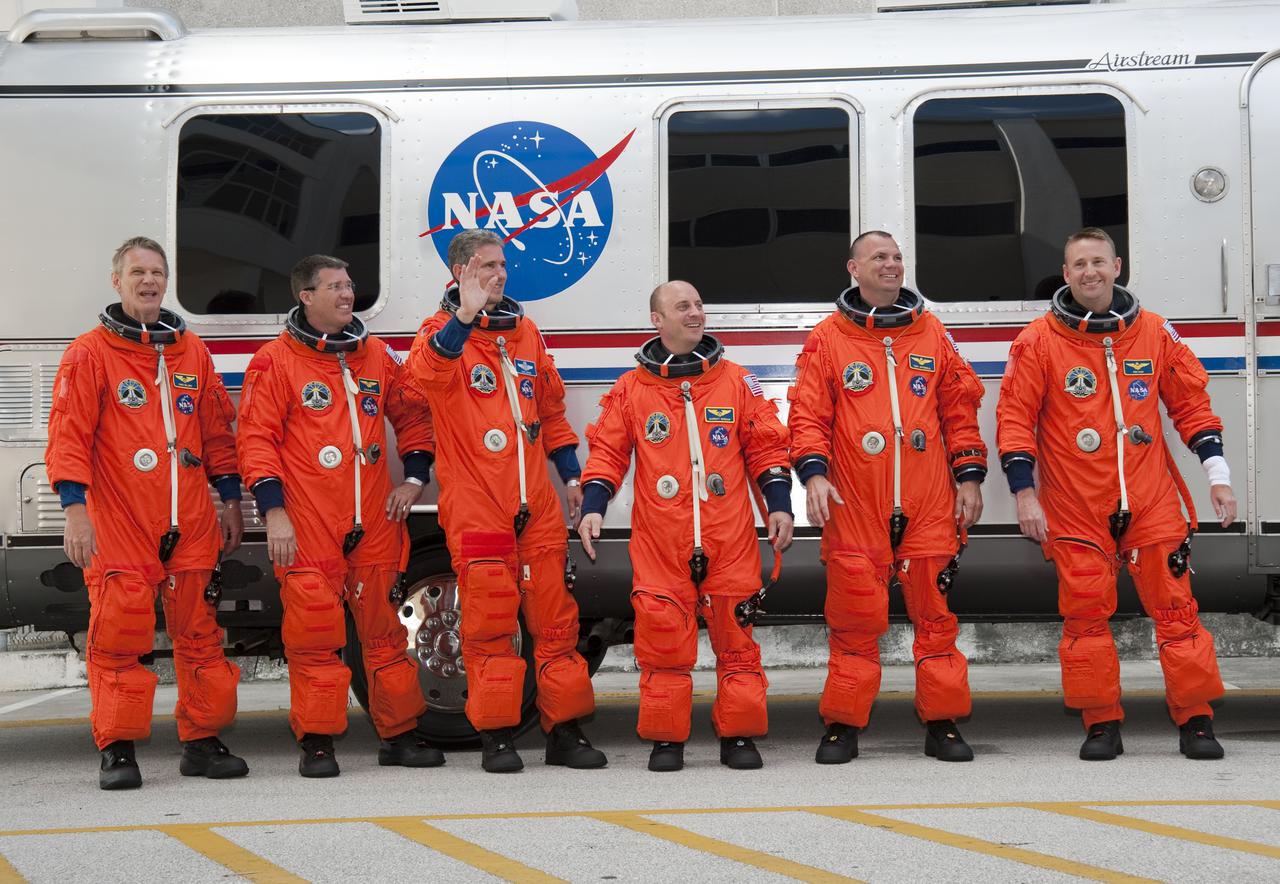 CAPE CANAVERAL, Fla. - At the Operations and Checkout Building at NASA's Kennedy Space Center in Florida, the astronauts on space shuttle Atlantis' STS-132 crew, dressed in their orange launch-and-entry suits, pause for a group portrait in front of the Astrovan which will transport them to Launch Pad 39A. From left are Mission Specialists Piers Sellers, Steve Bowen, Michael Good and Garrett Reisman; Pilot Tony Antonelli; and Commander Ken Ham. The white band on Ham's left wrist is a watch protector, which will make putting on his suit's gloves easier.  Liftoff of the STS-132 mission is set for 2:20 p.m. EDT on May 14.  The six-member STS-132 crew will deliver the Russian-built Mini Research Module-1 to the International Space Station.  Named Rassvet, Russian for 'dawn,' the module is the second in a series of new pressurized components for Russia and will be permanently attached to the Earth-facing port of the Zarya control module.  Rassvet will be used for cargo storage and will provide an additional docking port to the station. Also aboard Atlantis is an Integrated Cargo Carrier, or ICC, an unpressurized flat bed pallet and keel yoke assembly used to support the transfer of exterior cargo from the shuttle to the station.  STS-132 is the 34th mission to the station and the last scheduled flight for Atlantis. For more information on the STS-132 mission objectives, payload and crew, visit http:__www.nasa.gov_mission_pages_shuttle_shuttlemissions_sts132_index.html. Photo Credit: NASA_Kim Shiflett