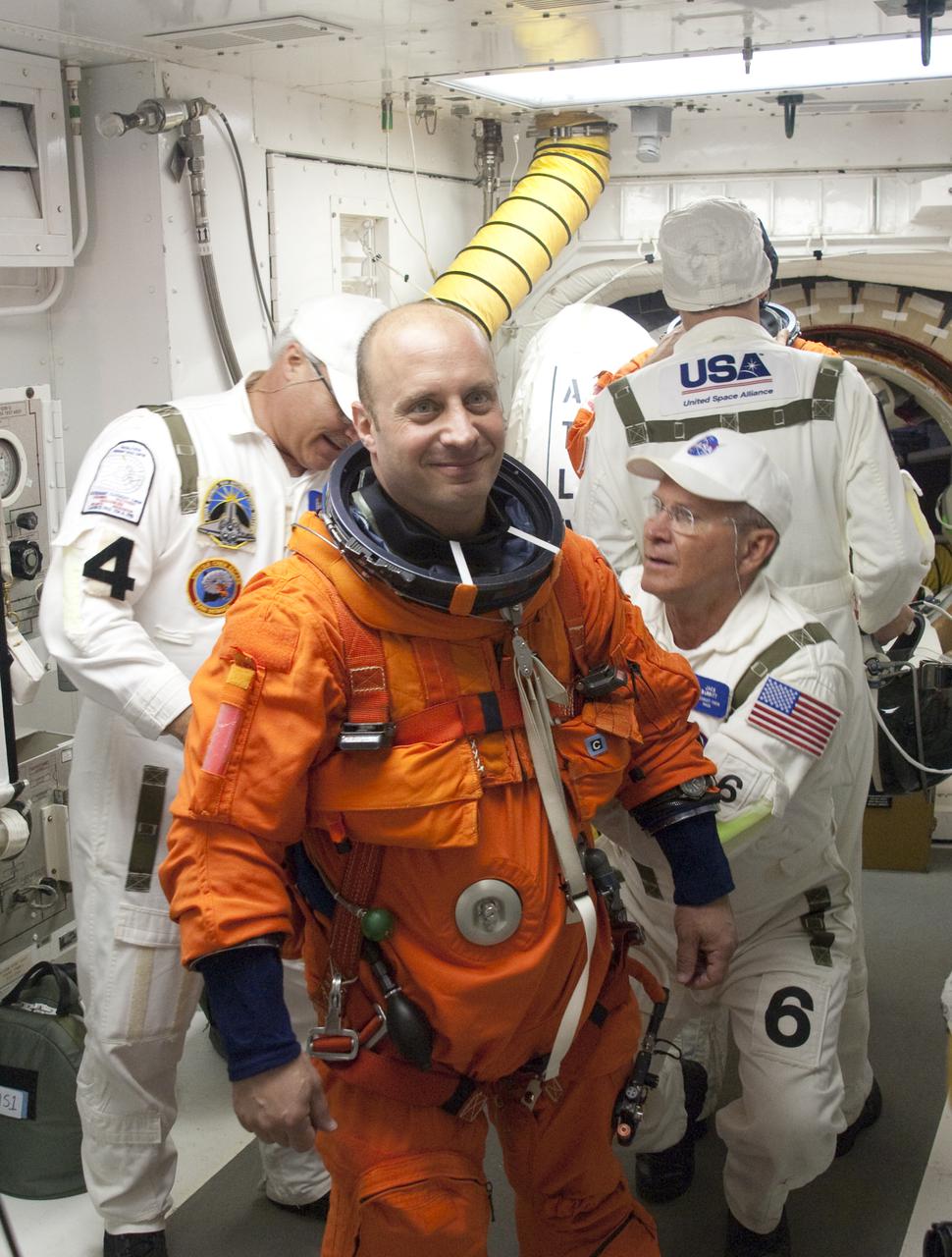 CAPE CANAVERAL, Fla. - In the White Room at Launch Pad 39A at NASA's Kennedy Space Center in Florida, United Space Alliance space suit technicians help STS-132 Mission Specialist Garrett Reisman put on the parachute for his launch-and-entry suit before he enters space shuttle Atlantis through the crew hatch in the background.  Reisman was a flight engineer on the International Space Station's Expedition 16 and 17.  Liftoff of the STS-132 mission is set for 2:20 p.m. EDT on May 14.  The six-member STS-132 crew will deliver the Russian-built Mini Research Module-1 to the International Space Station.  Named Rassvet, Russian for 'dawn,' the module is the second in a series of new pressurized components for Russia and will be permanently attached to the Earth-facing port of the Zarya control module.  Rassvet will be used for cargo storage and will provide an additional docking port to the station. Also aboard Atlantis is an Integrated Cargo Carrier, or ICC, an unpressurized flat bed pallet and keel yoke assembly used to support the transfer of exterior cargo from the shuttle to the station.  STS-132 is the 34th mission to the station and the last scheduled flight for Atlantis. For more information on the STS-132 mission objectives, payload and crew, visit http:__www.nasa.gov_mission_pages_shuttle_shuttlemissions_sts132_index.html. Photo Credit: NASA_Sandra Joseph and Kevin O'Connell
