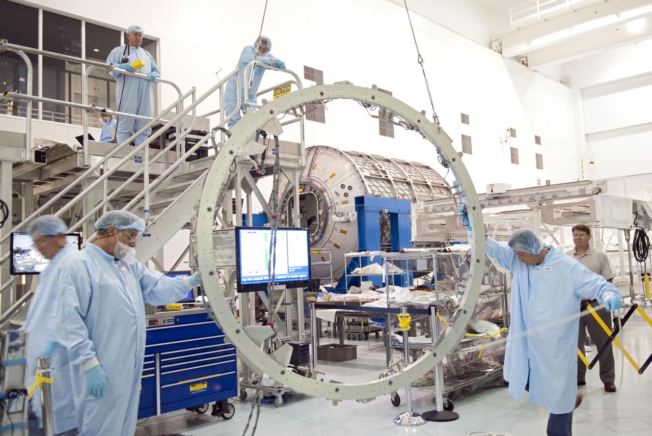 CAPE CANAVERAL, Fla. – Technicians in the Space Station Processing Facility at NASA's Kennedy Space Center in Florida begin to hoist and temporarily install the Common Berthing Mechanism, or CBM, to the Permanent Multipurpose Module, or PMM. The CBM is a test fixture that simulates the joining of the International Space Station with a pressurized element. The Leonardo multi-purpose logistics module, or MPLM, is being modified to become the PMM that will carry supplies and critical spare parts to the station aboard space shuttle Discovery’s STS-133 mission. Discovery will leave the module behind so it can be used for microgravity experiments in fluid physics, materials science, biology and biotechnology. Photo credit: NASA_Jim Grossmann