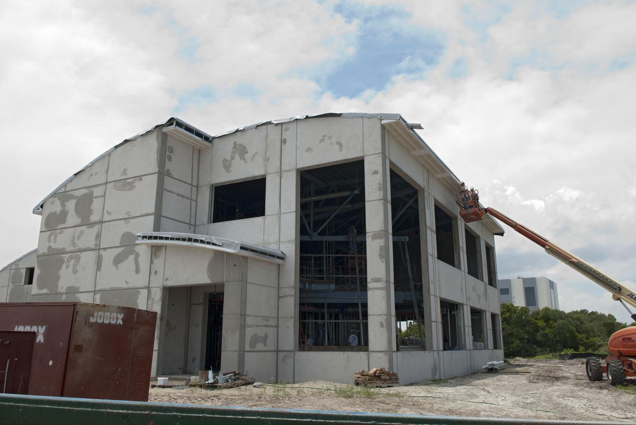 CAPE CANAVERAL, Fla. - At the Propellants North Administrative and Maintenance Facility at NASA's Kennedy Space Center in Florida, workers prepare to install window glazing and framing recycled from the iconic firing rooms of the Launch Control Center. New energy-efficient windows will be set at the same orientation and angle as the old windows were at the control center, looking out toward Launch Complex 39. The green facility will have a two-story administrative building to house managers, mechanics and technicians who fuel spacecraft at Kennedy adjacent to a single-story shop to store cryogenic fuel transfer equipment.   The facility is striving to qualify for the U.S. Green Building Council’s Leadership in Energy and Environmental Design, or LEED, Platinum certification. If successful, it will be the first NASA facility to achieve this highest of LEED ratings after it is completed in December 2010. The facility was designed for NASA by Jones Edmunds and Associates. H. W. Davis Construction is the construction contractor. Photo credit: NASA_Jim Grossmann